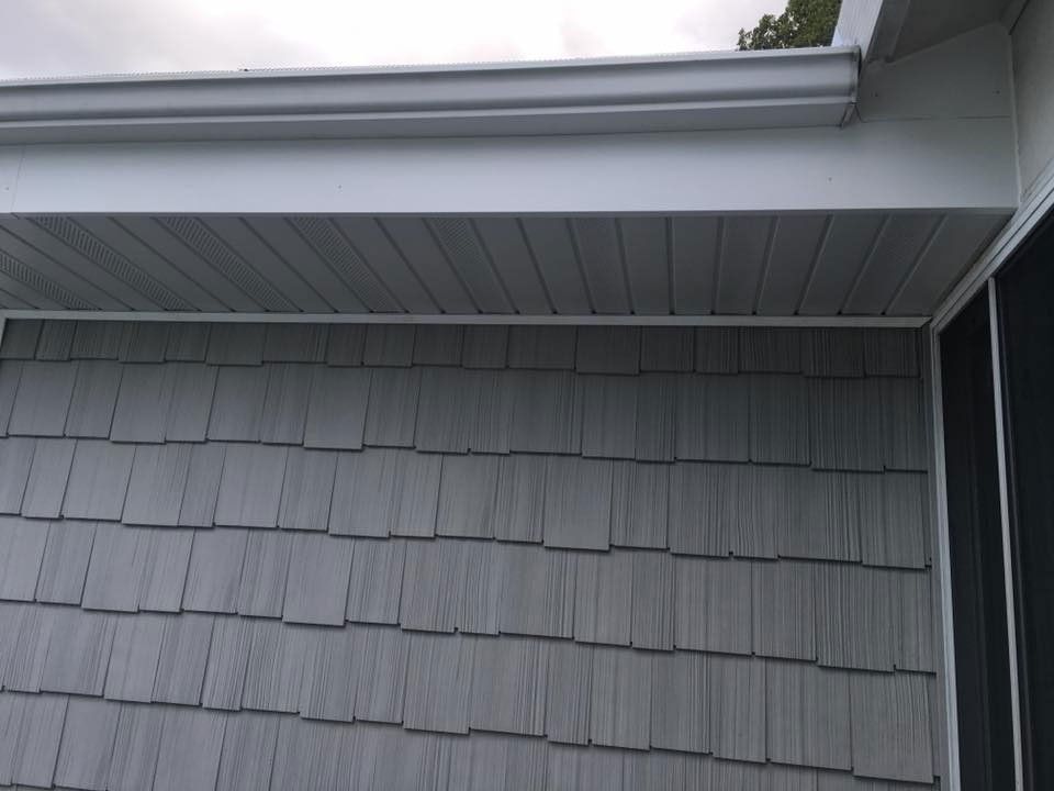 Gray siding, soffit, and gutter on a building's exterior.