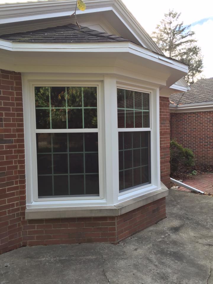 Bay window with white trim on a brick house.