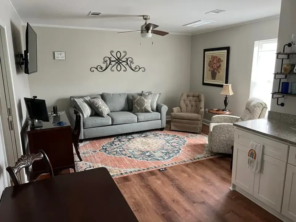 A living room with a couch , chairs , and a television.