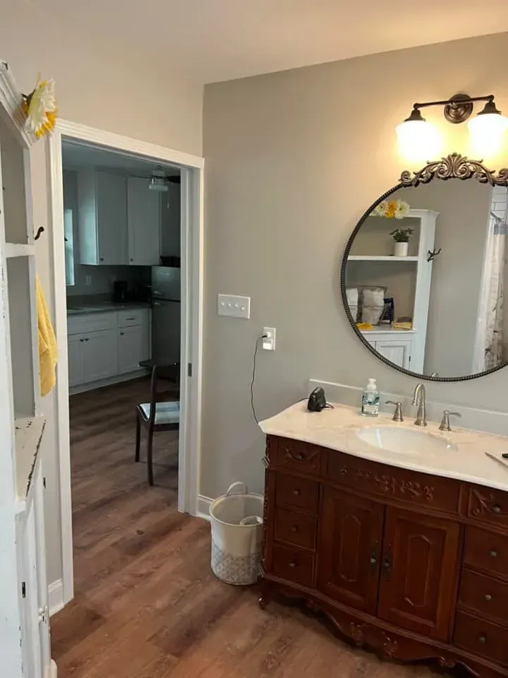 A bathroom with a sink , mirror and cabinets.