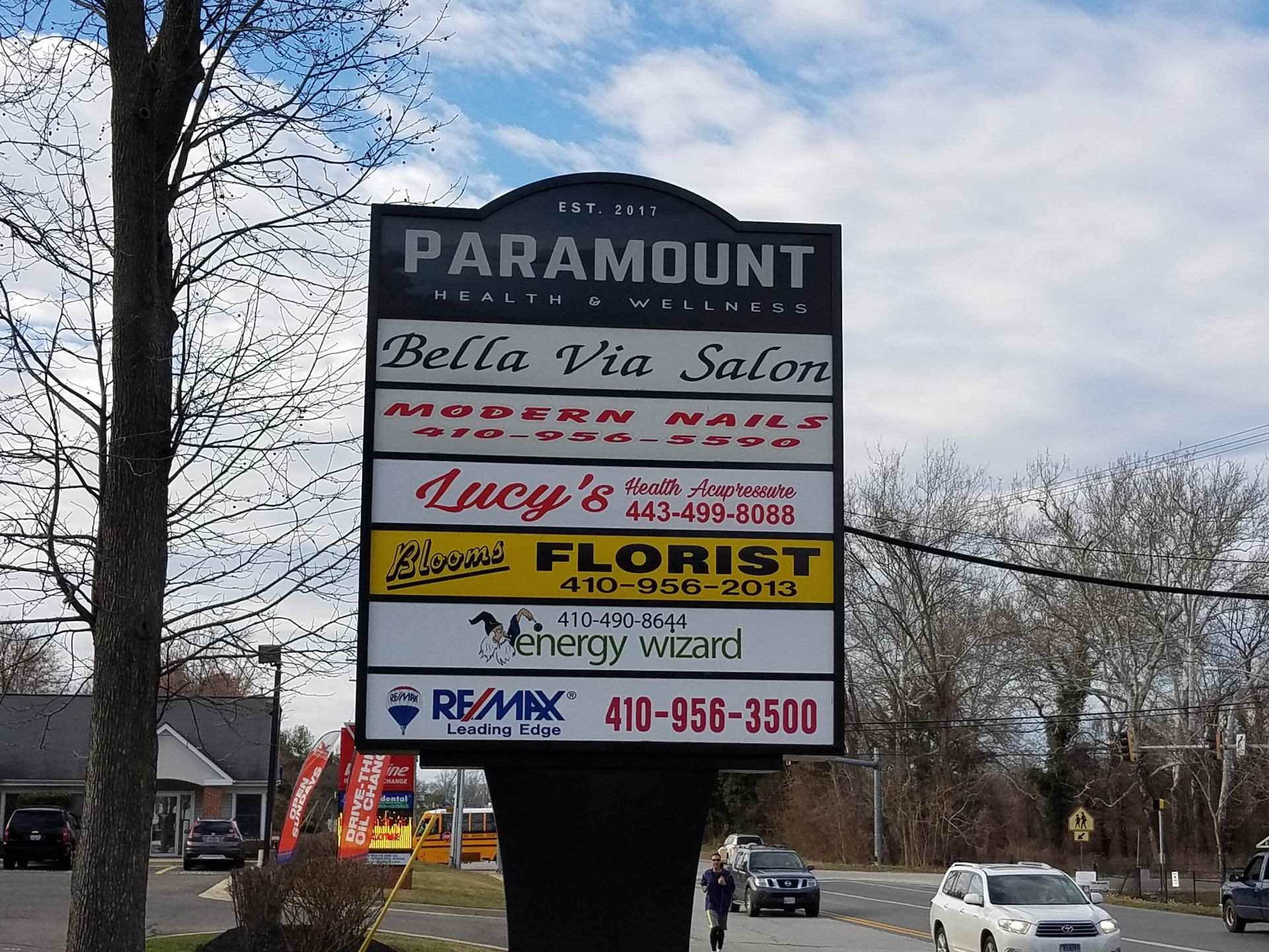 A sign for Paramount Bella Via salon and Lucy's Florist