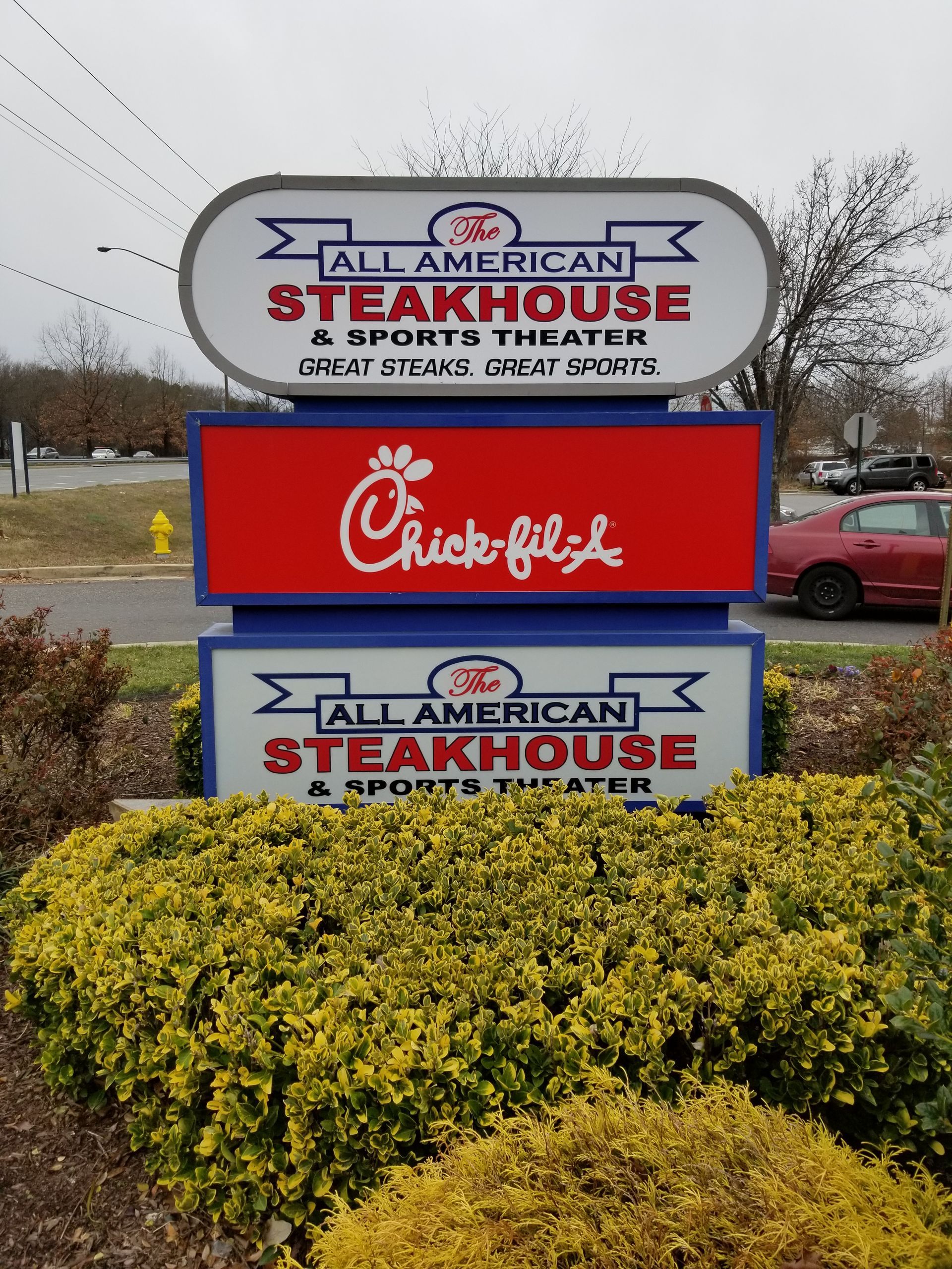 A sign for all american steakhouse and chick-fil-a