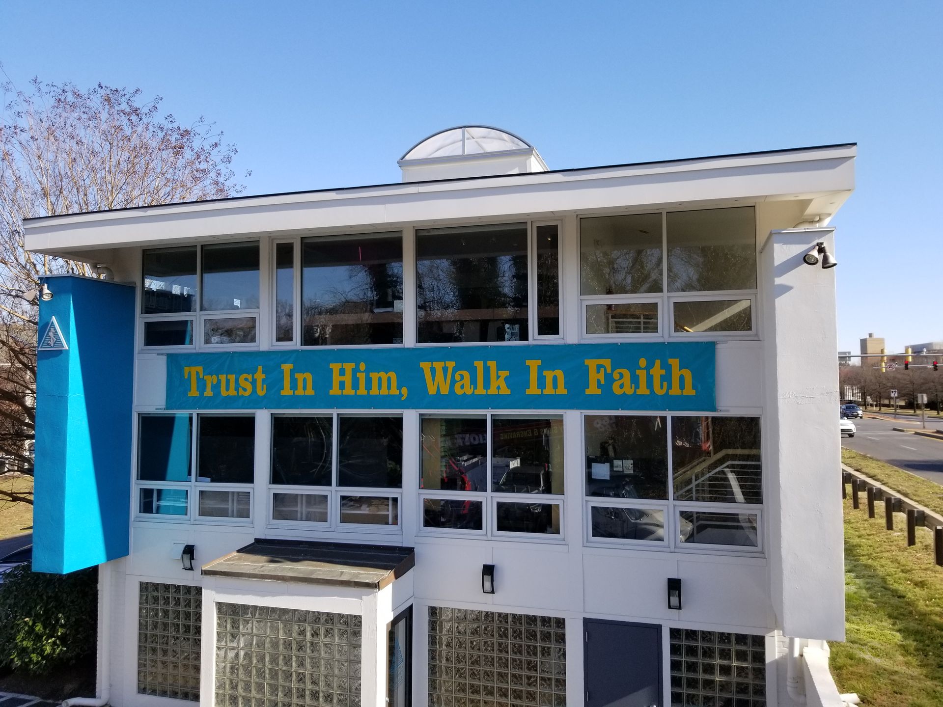 A building with a sign that says trust in him walk in faith