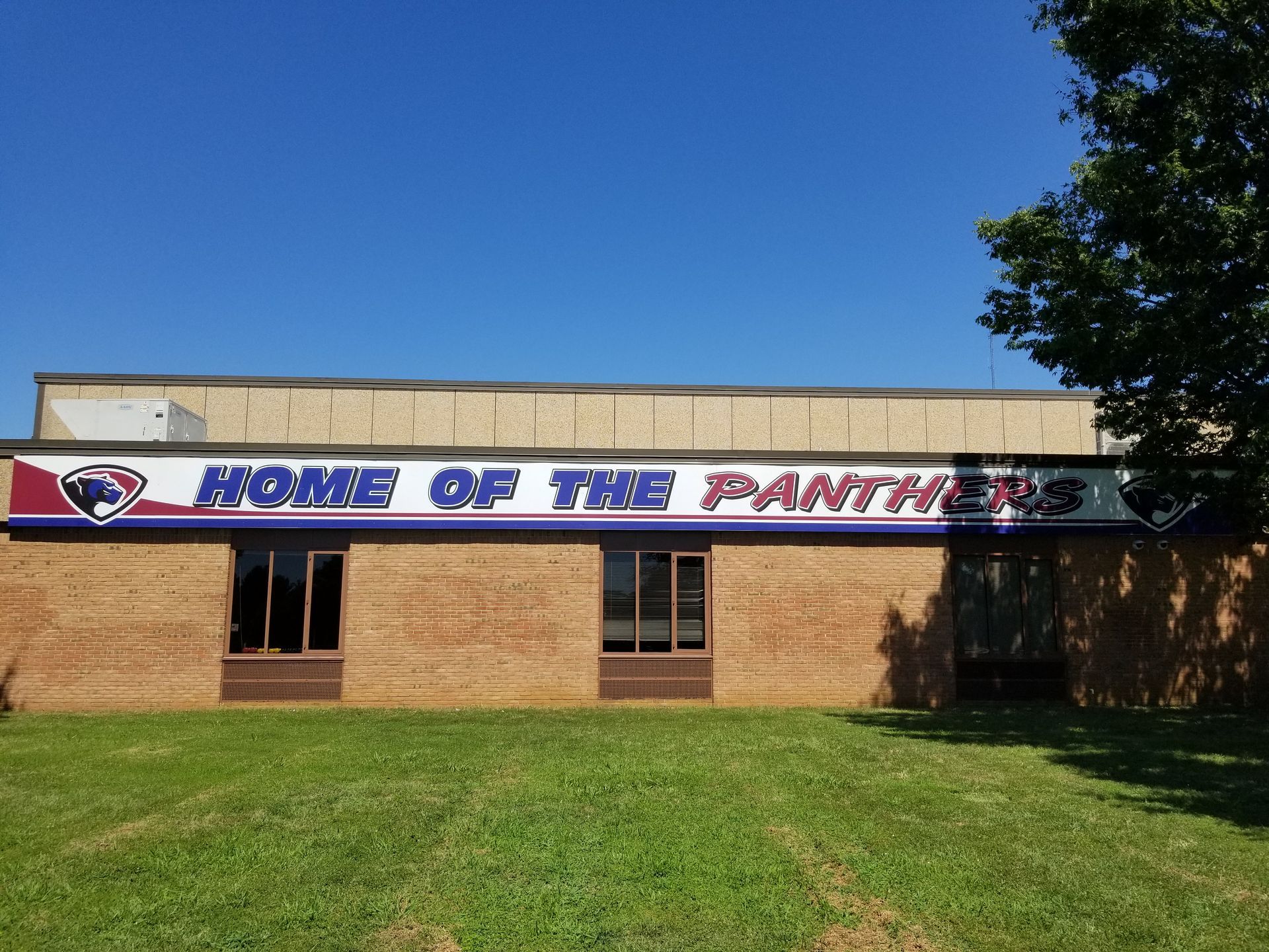 A brick building with a sign that says home of the panthers
