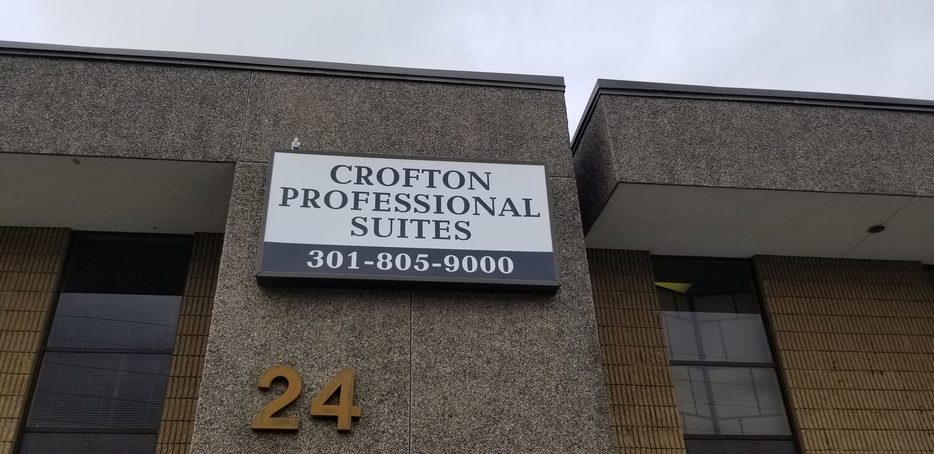 A building with a sign on it that says crofton professional suites