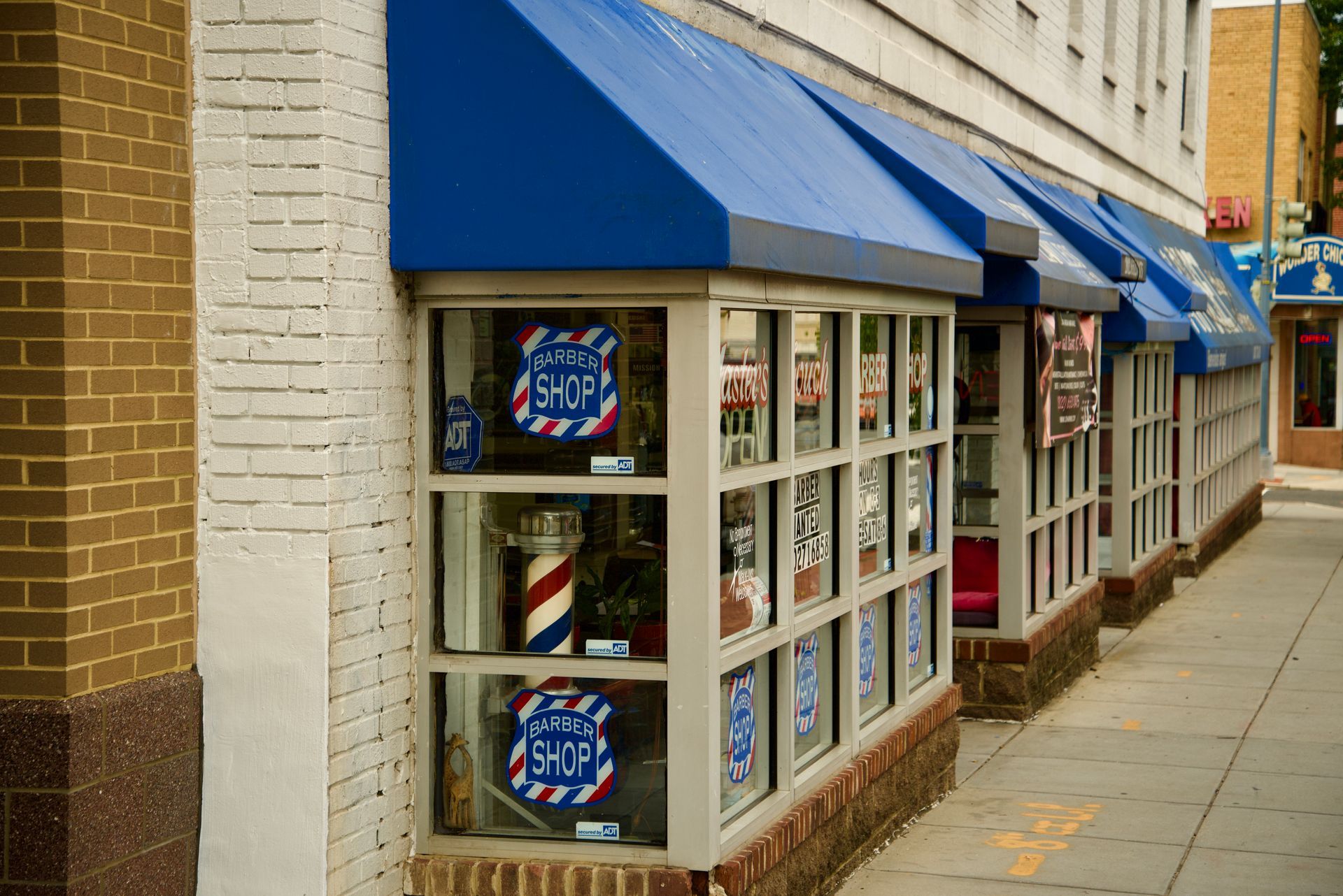 A row of barber shops with blue awnings