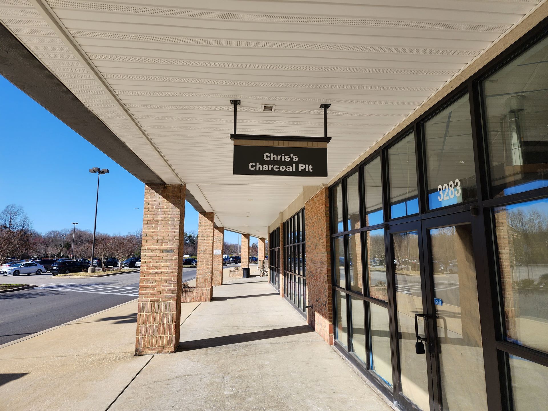 A long walkway between two buildings with a sign hanging from the ceiling.