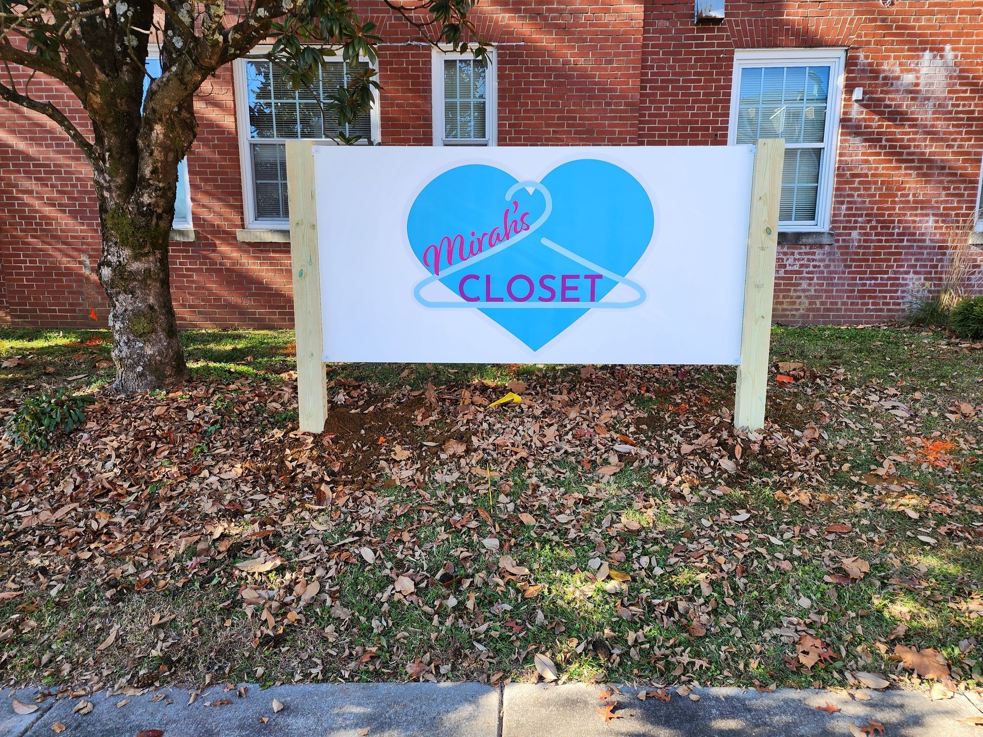 A sign in front of a brick building says friends closet