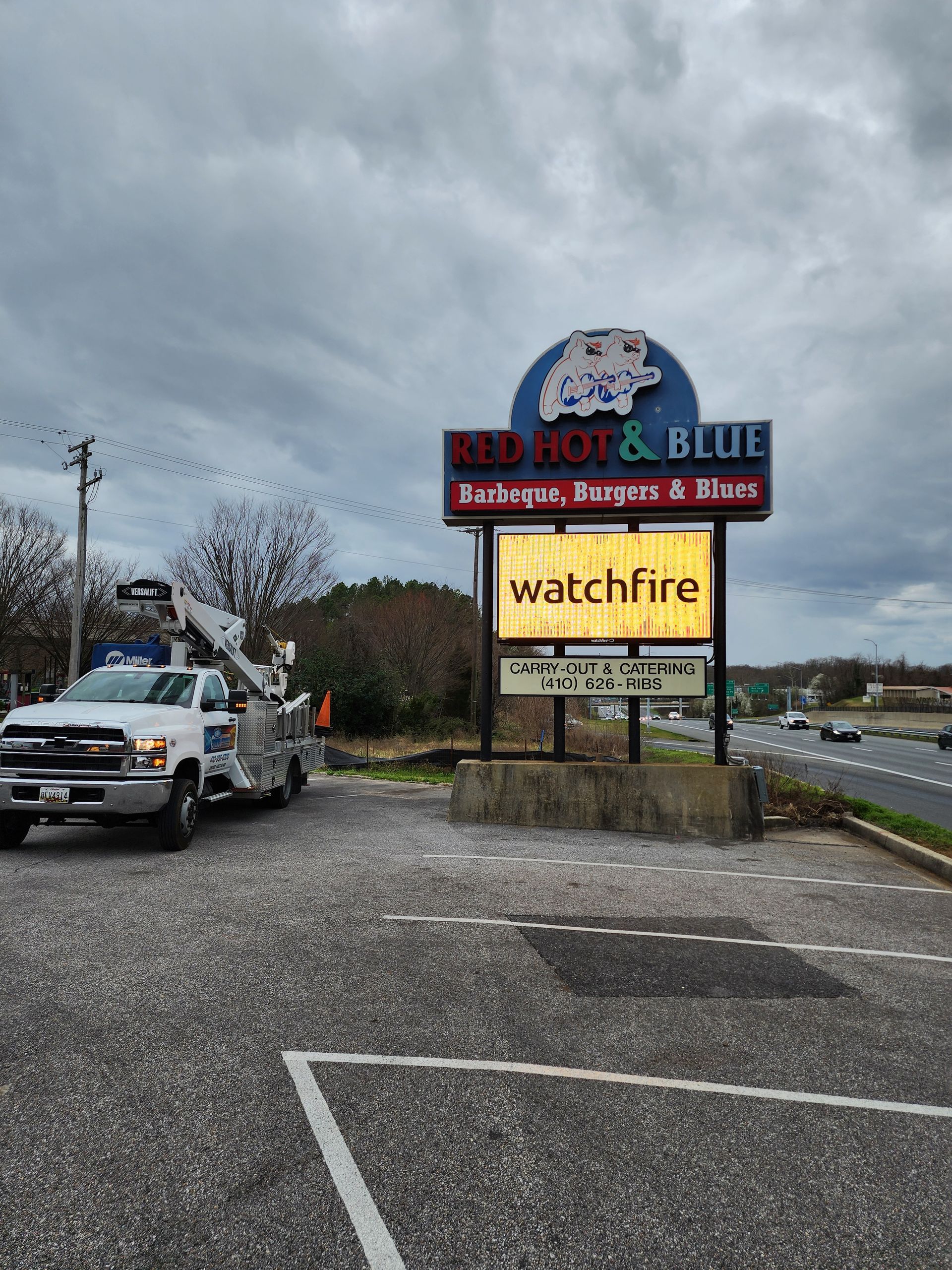 A truck is parked in front of a sign that says watchfire.