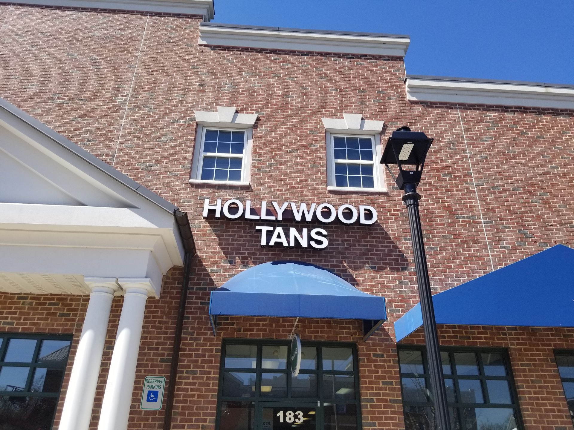 A brick building with a sign that says hollywood tans