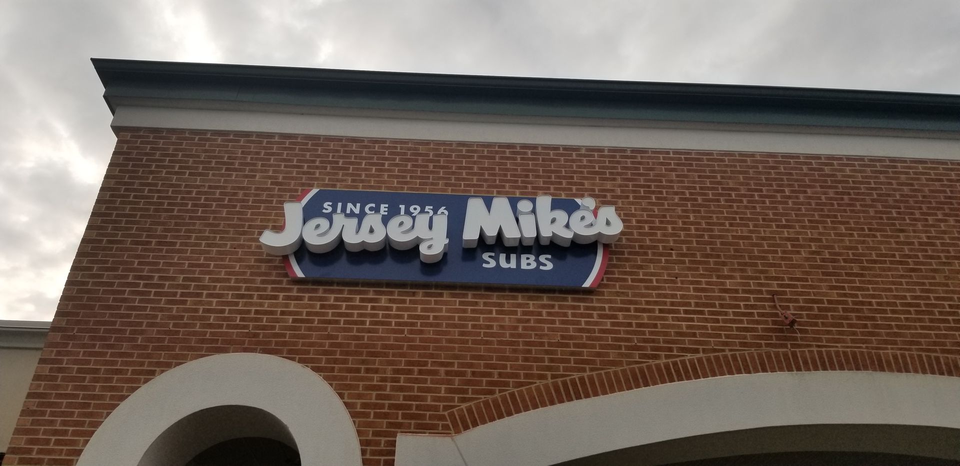 A jersey mikes sub shop is located on a brick building.