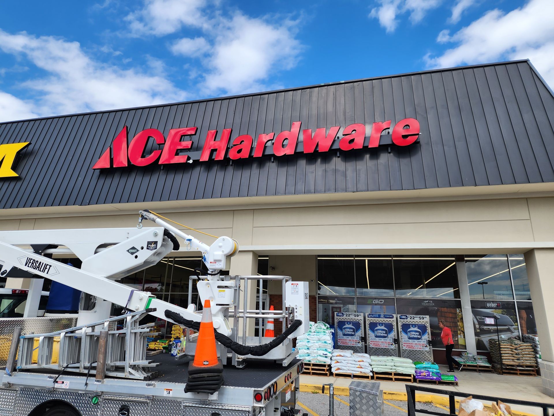 A crane is sitting in front of a hardware store.