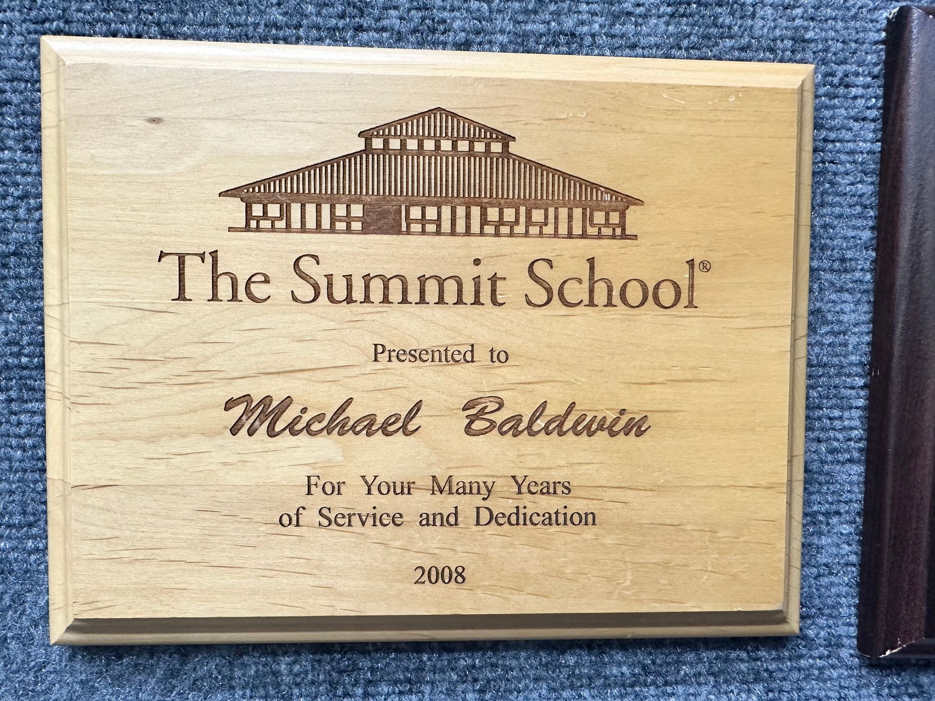 A wooden plaque from the summit school presented to michael baldwin