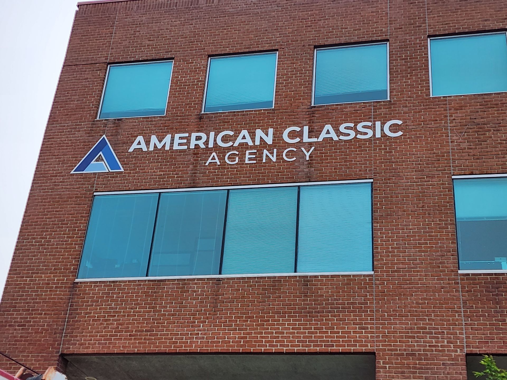 A brick building with a sign that says american classic agency