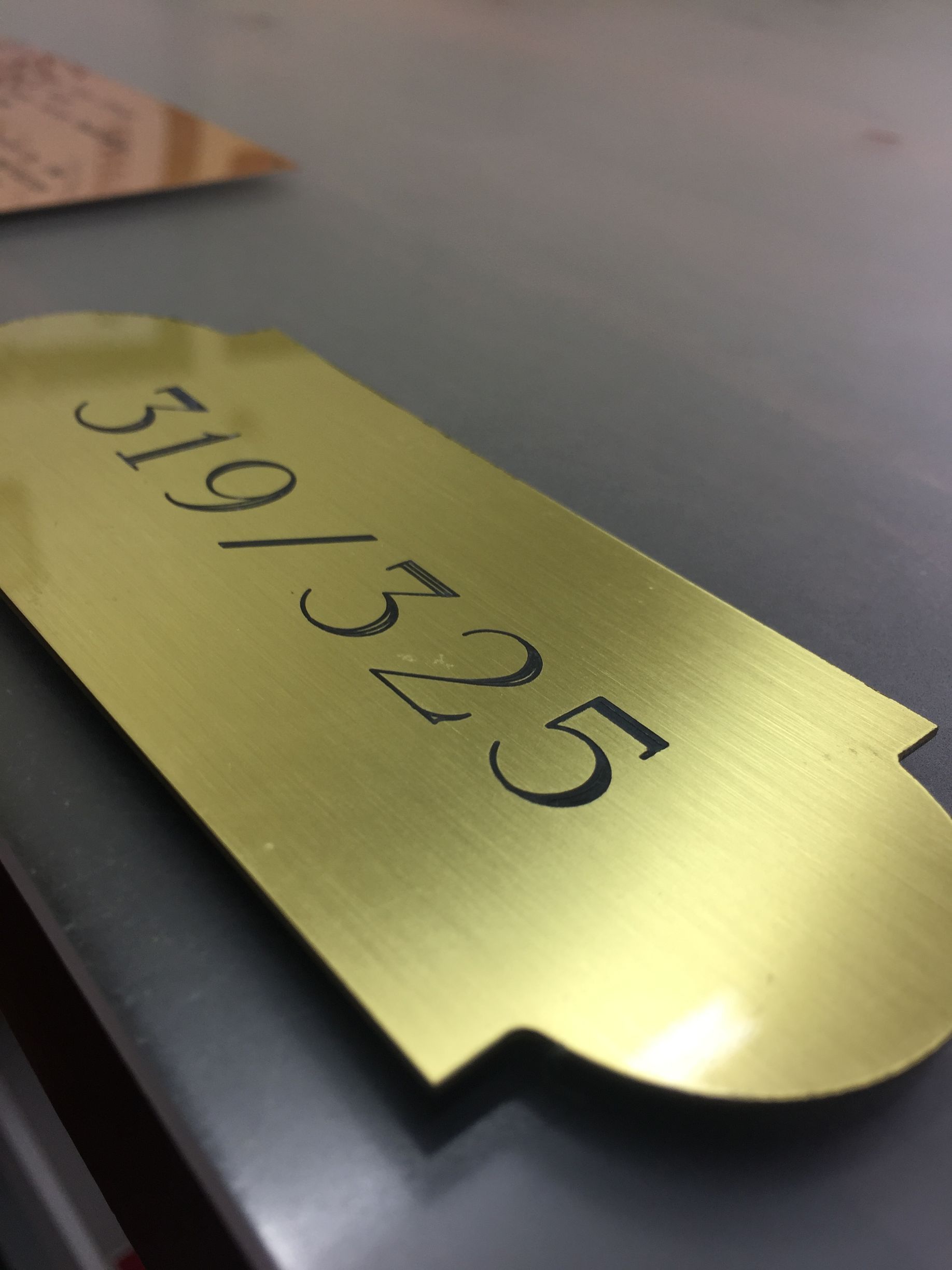 A close up of a gold sign with the number 5 on it