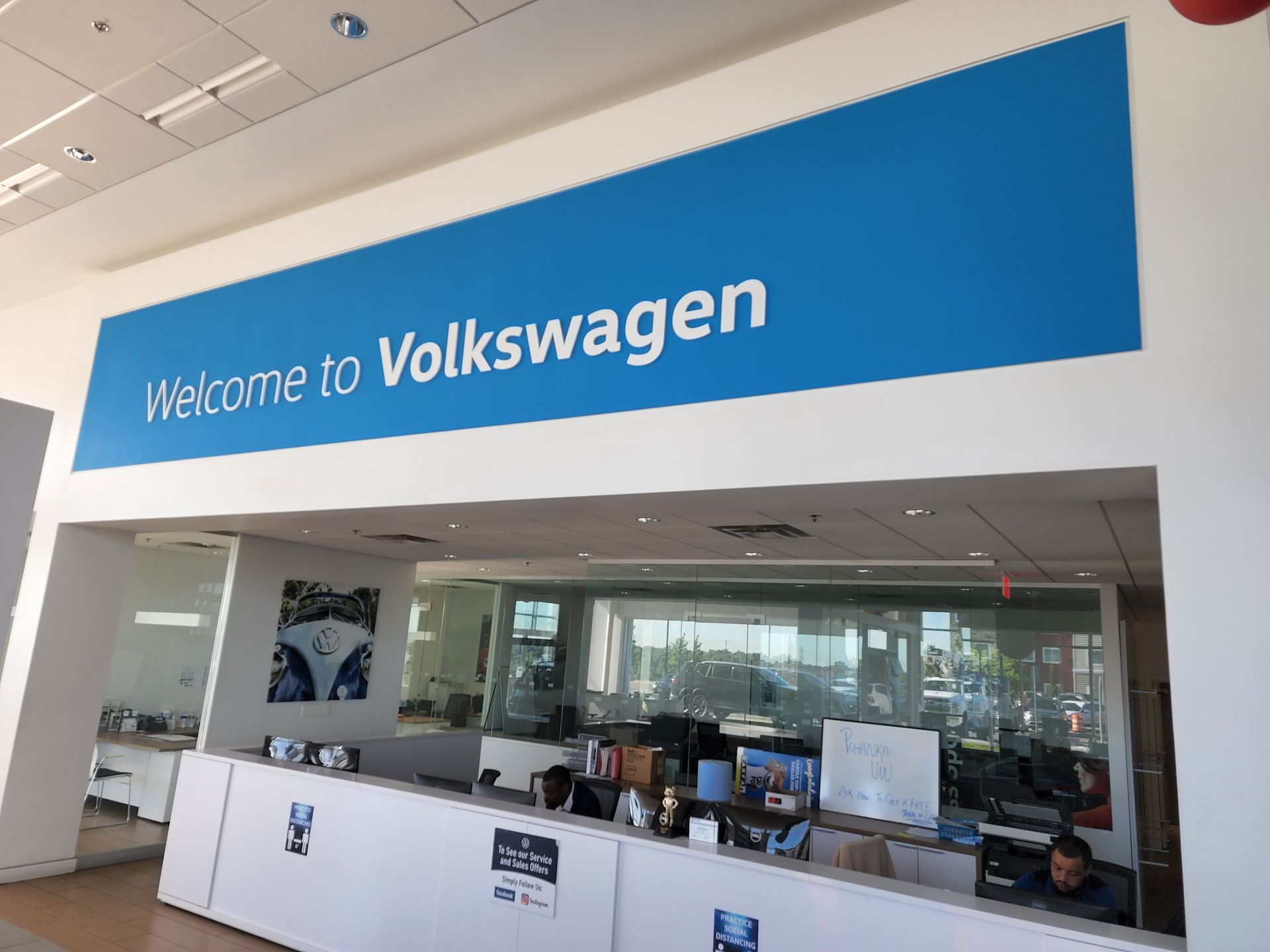 A blue sign that says welcome to volkswagen on it