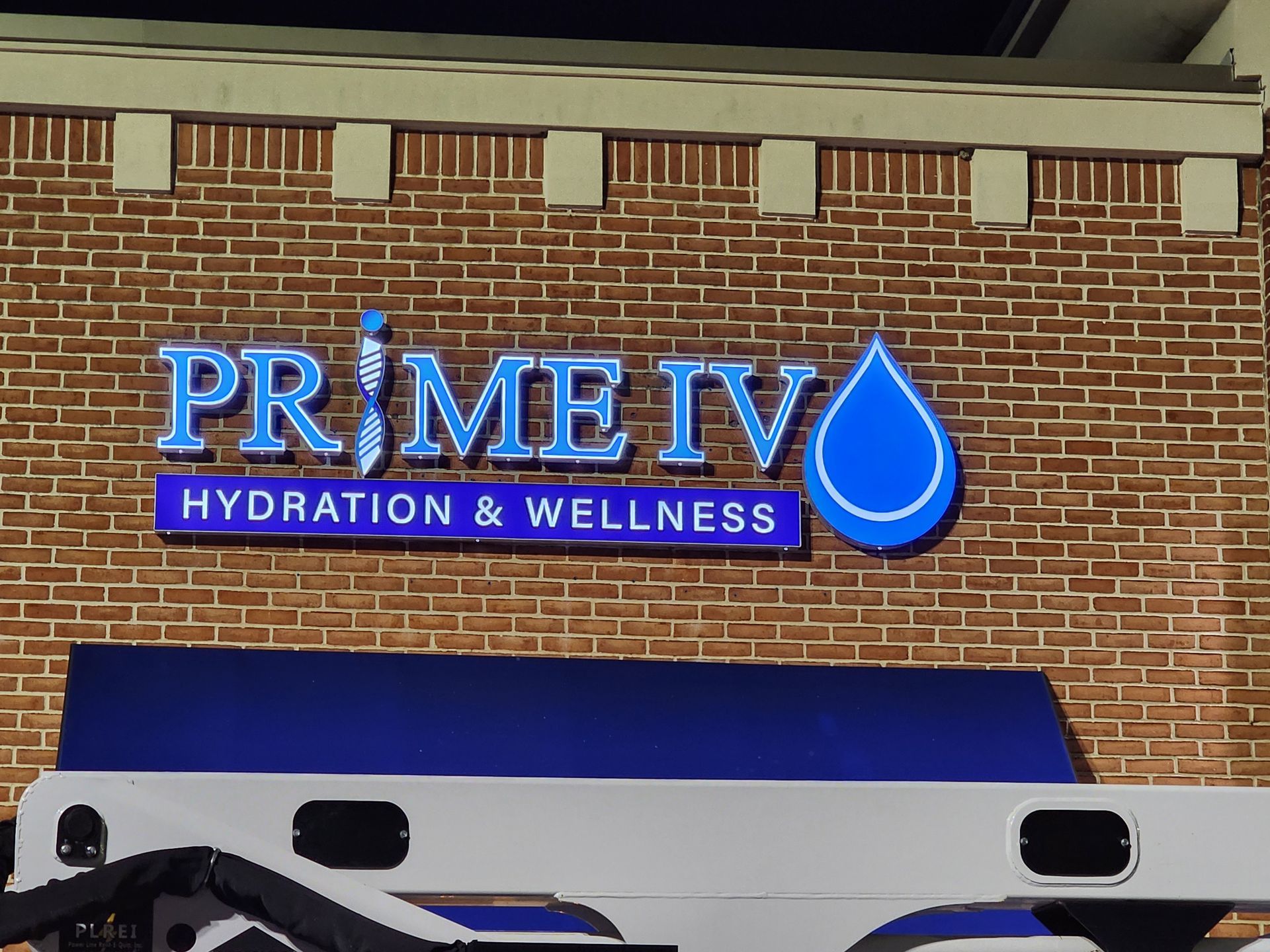 A sign for prime iv hydration and wellness on a brick building