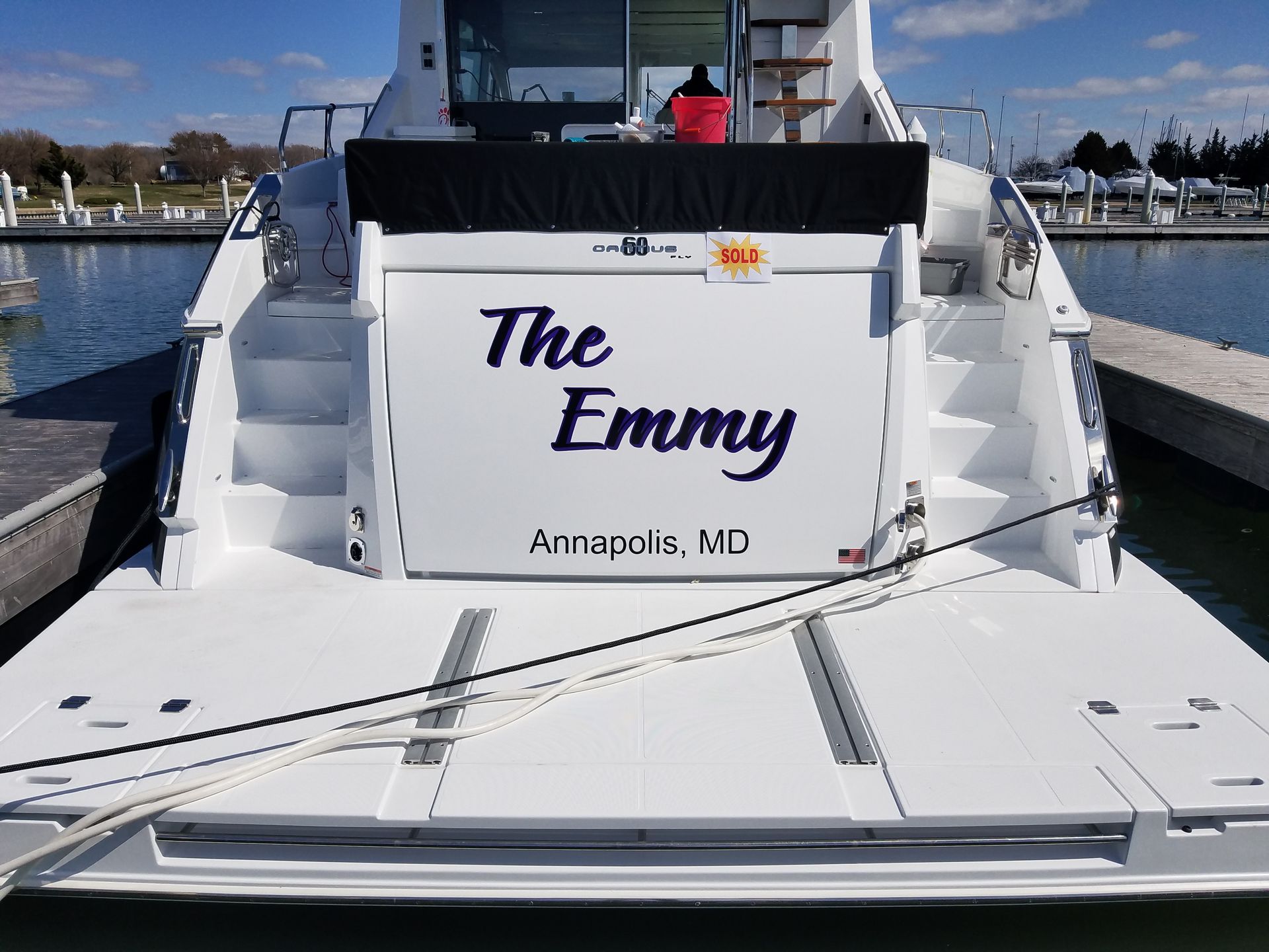 A boat named the emmy is docked at a marina
