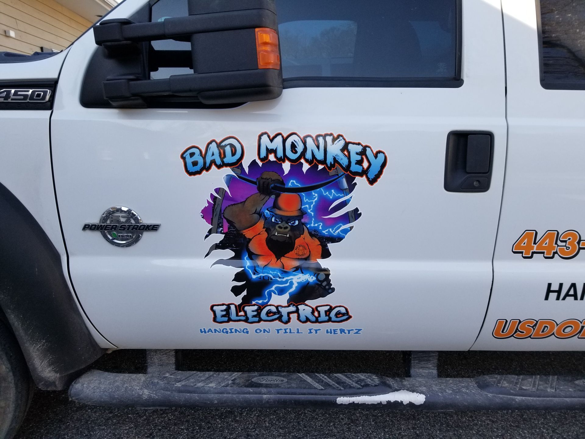A white truck with bad monkey electric written on the side