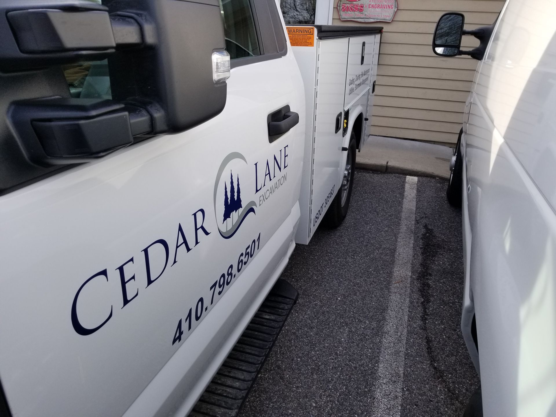Two cedar lane trucks are parked next to each other