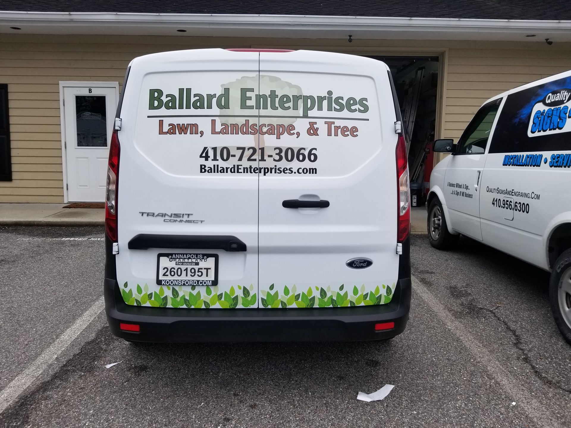 A white van is parked in front of a building that says ballard enterprises