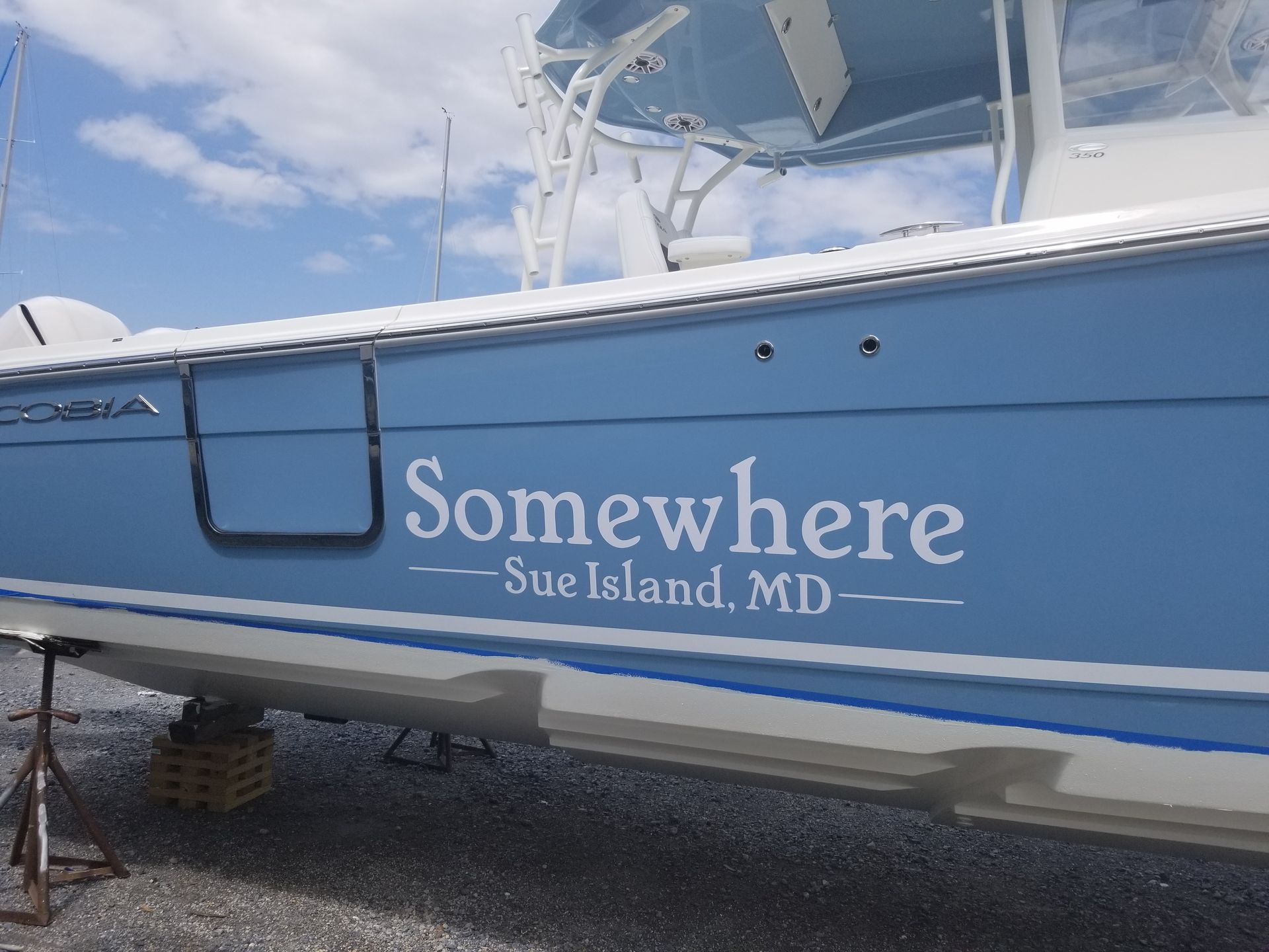 A blue boat with the name somewhere on it