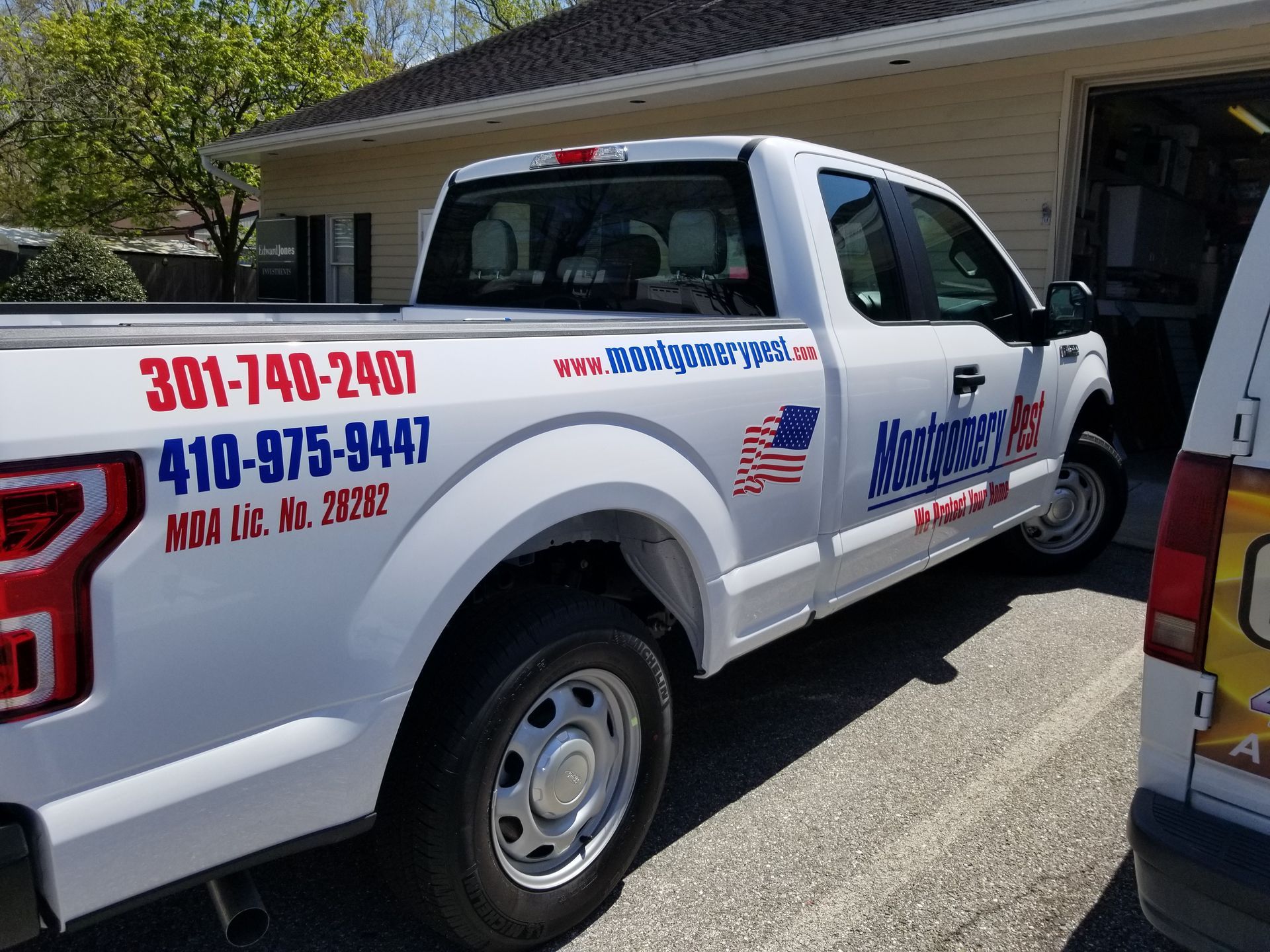A white truck is parked in front of a house.