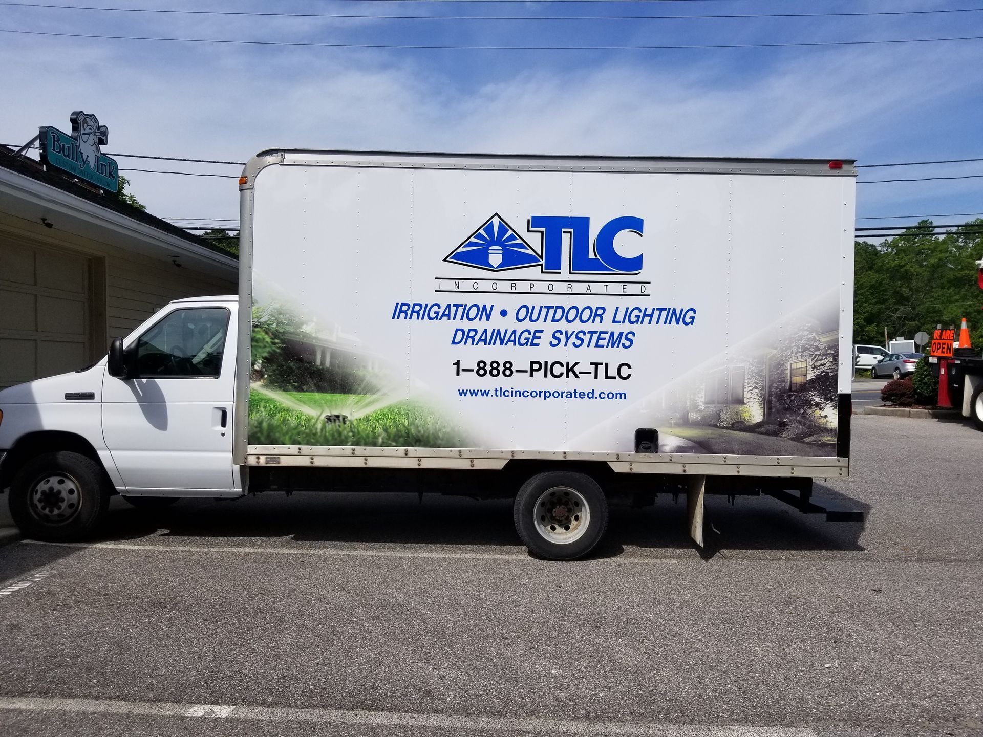 A white tlc truck is parked in a parking lot