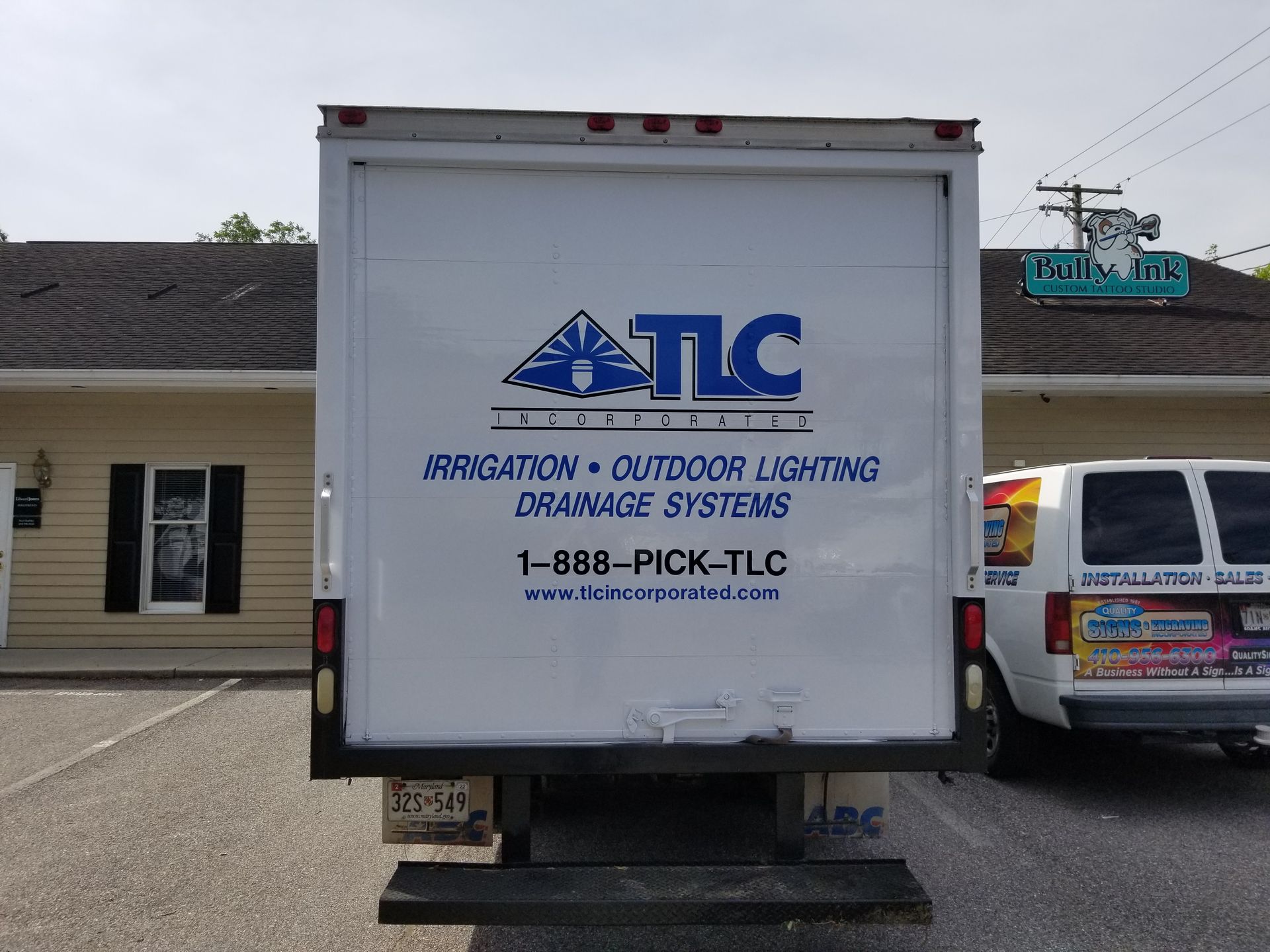 A tlc truck is parked in front of a building