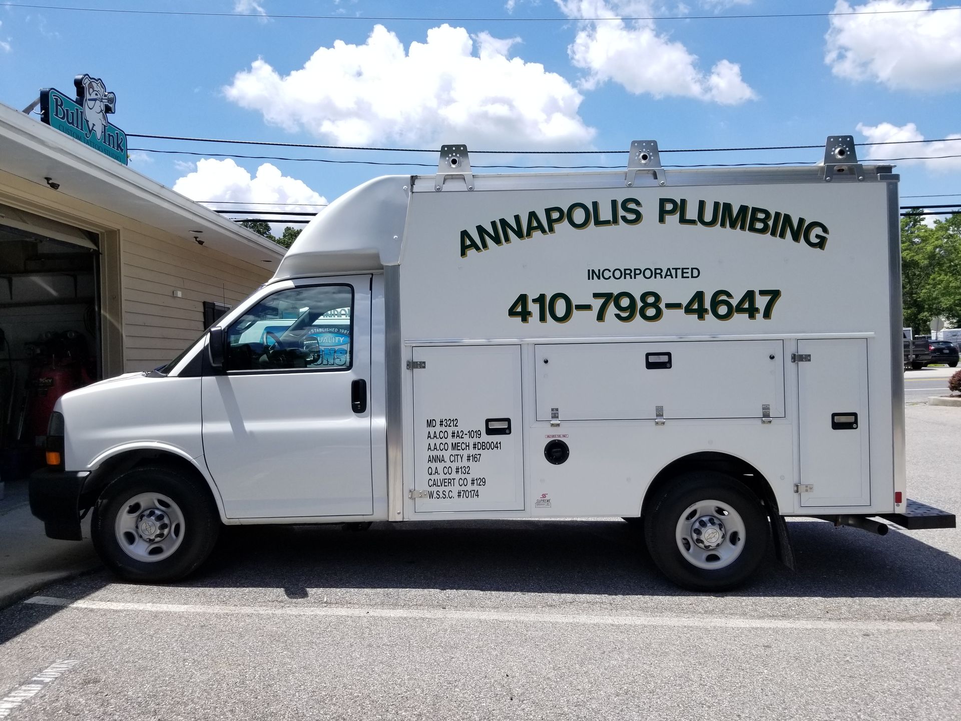 A white van for annapolis plumbing is parked in a parking lot