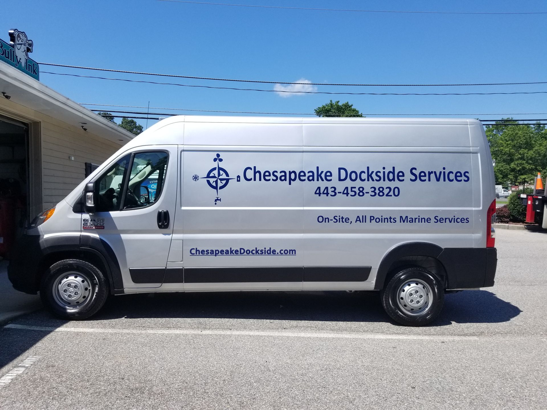 A gray van with the words chesapeake dockside services on the side is parked in a parking lot.