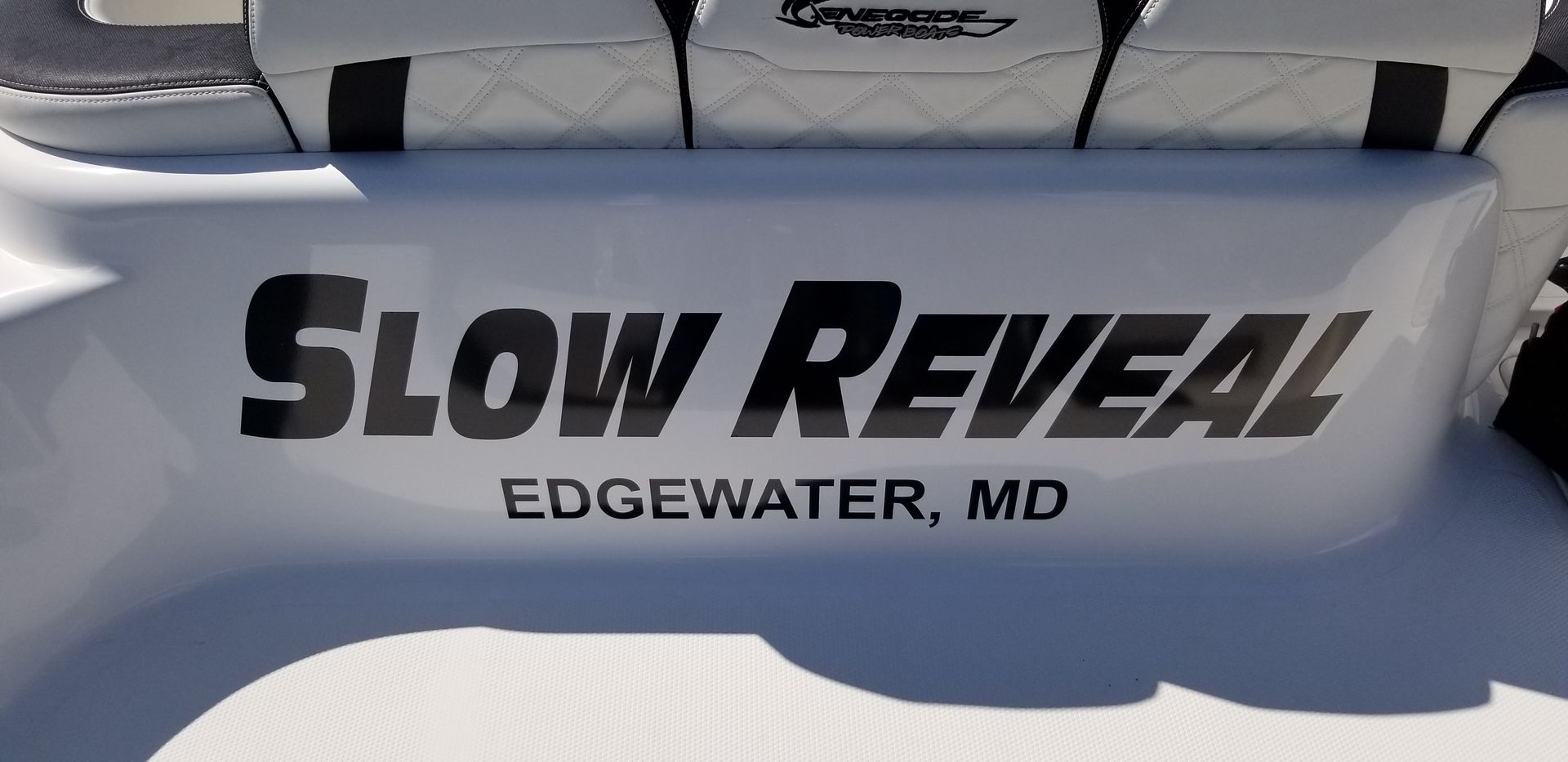 The back of a boat with the words slow reveal written on it