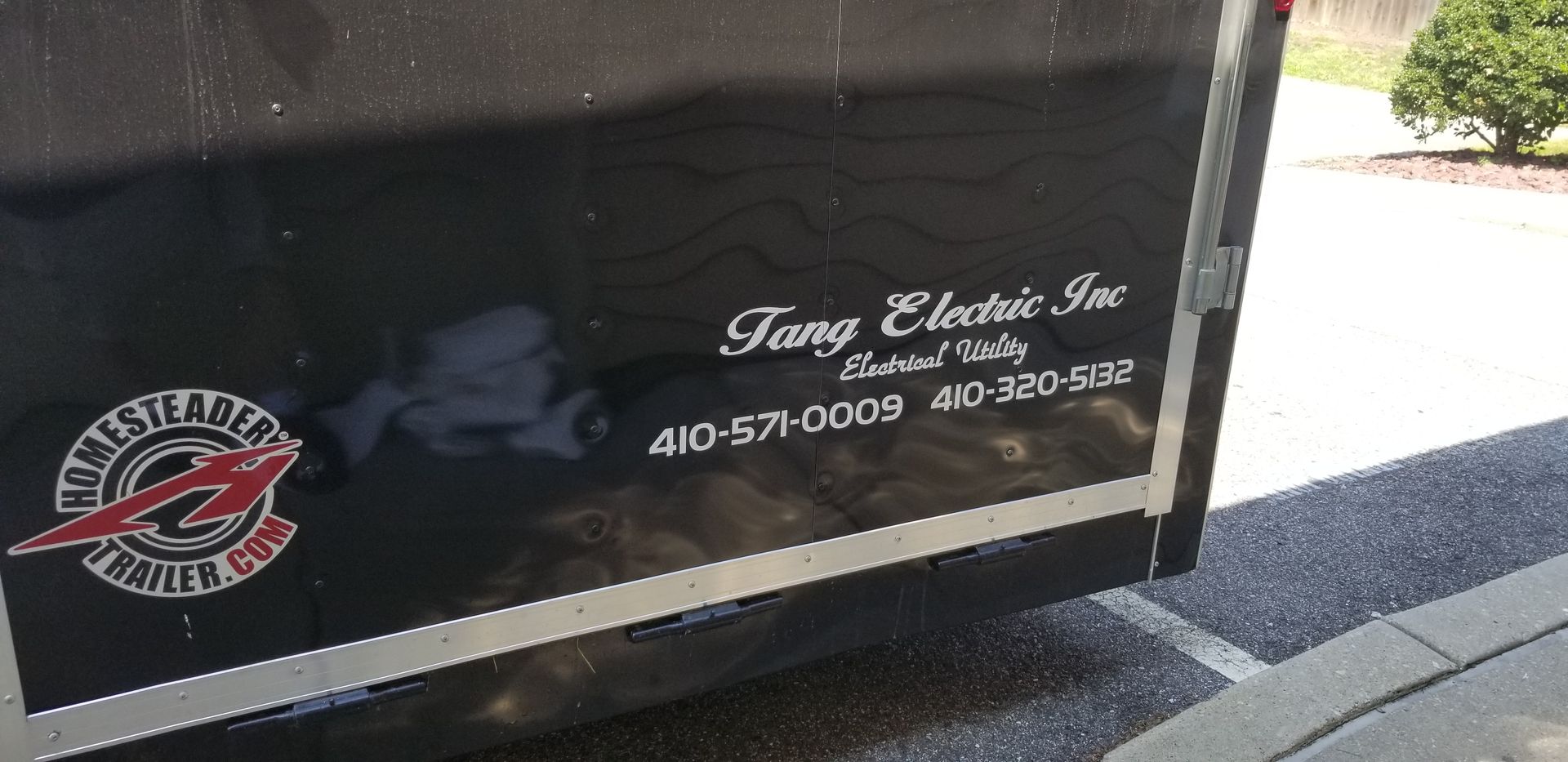 A black trailer with fang electric inc. written on it