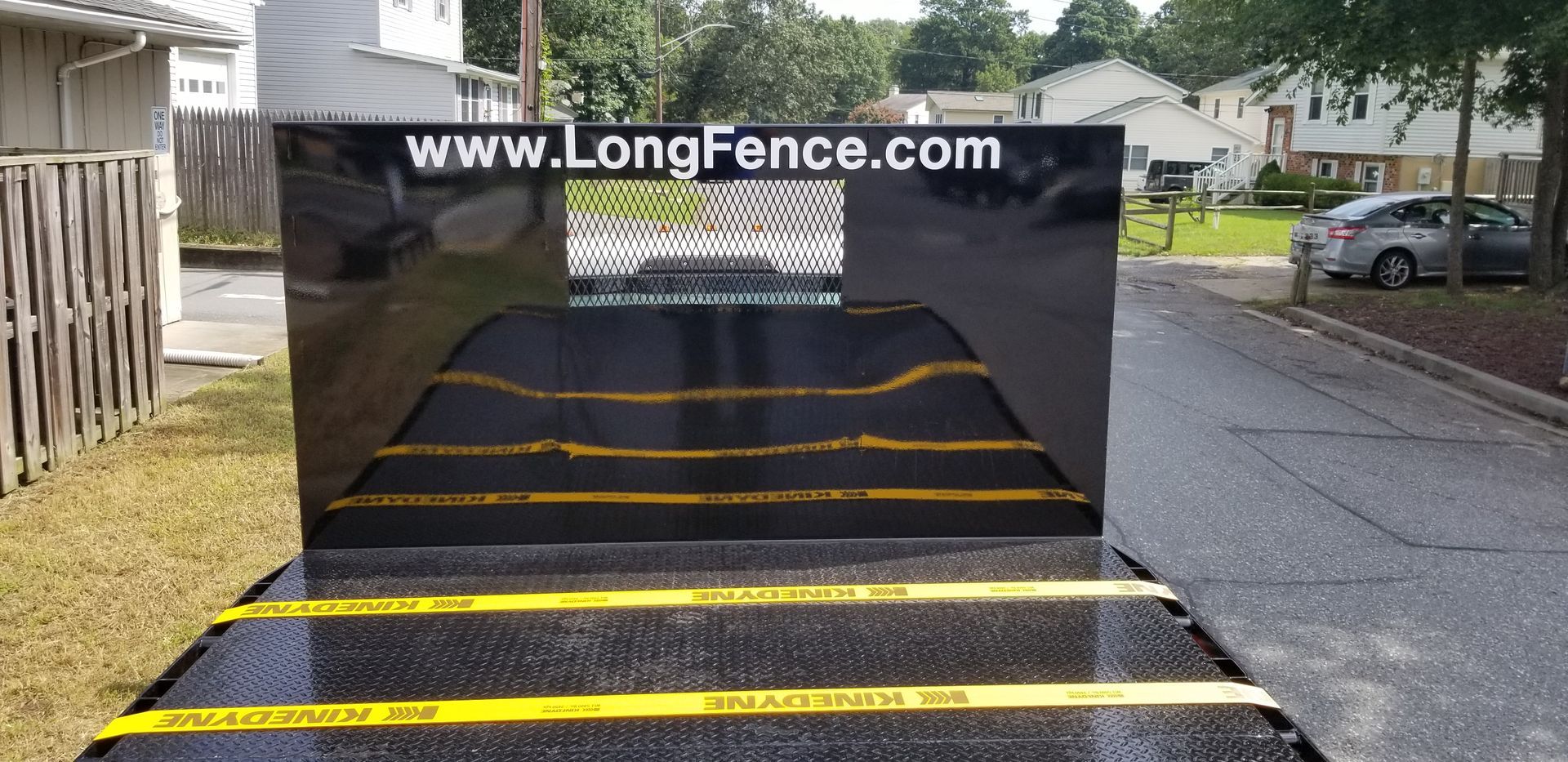 A long fence is sitting on the side of the road.