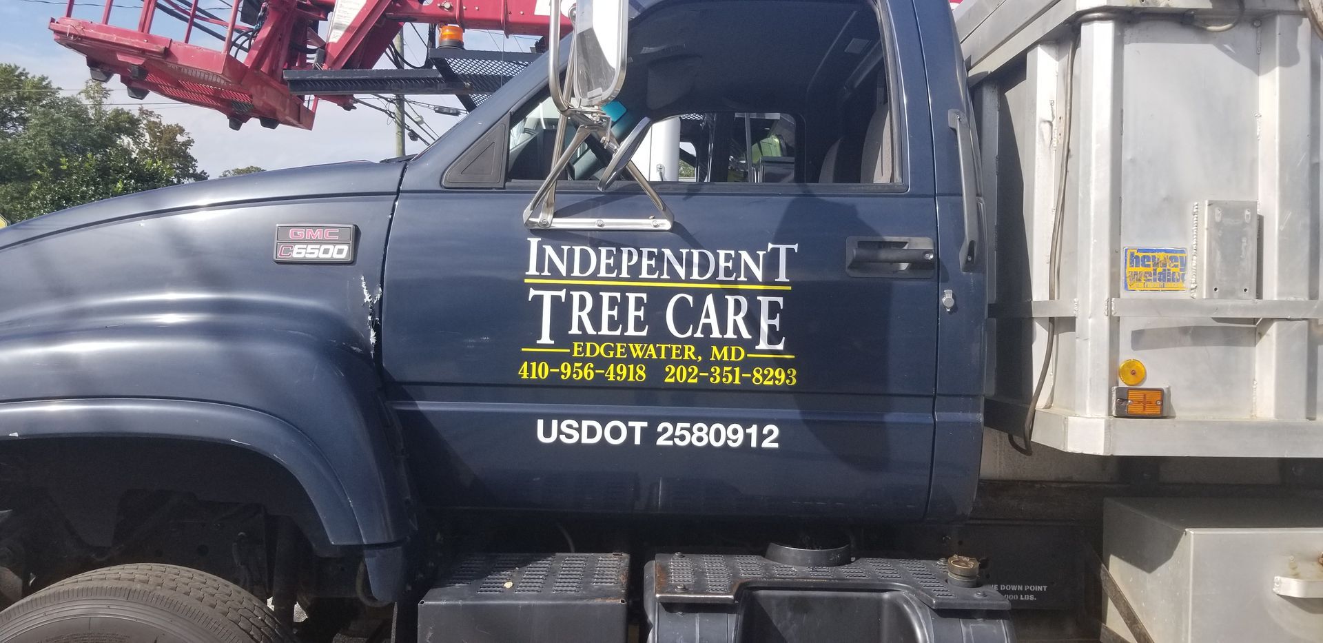 An independent tree care truck is parked in a parking lot.