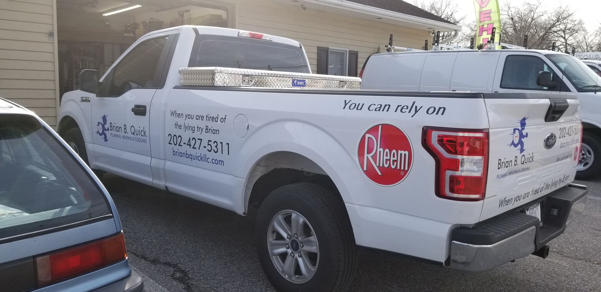 A white truck is parked in front of a building.
