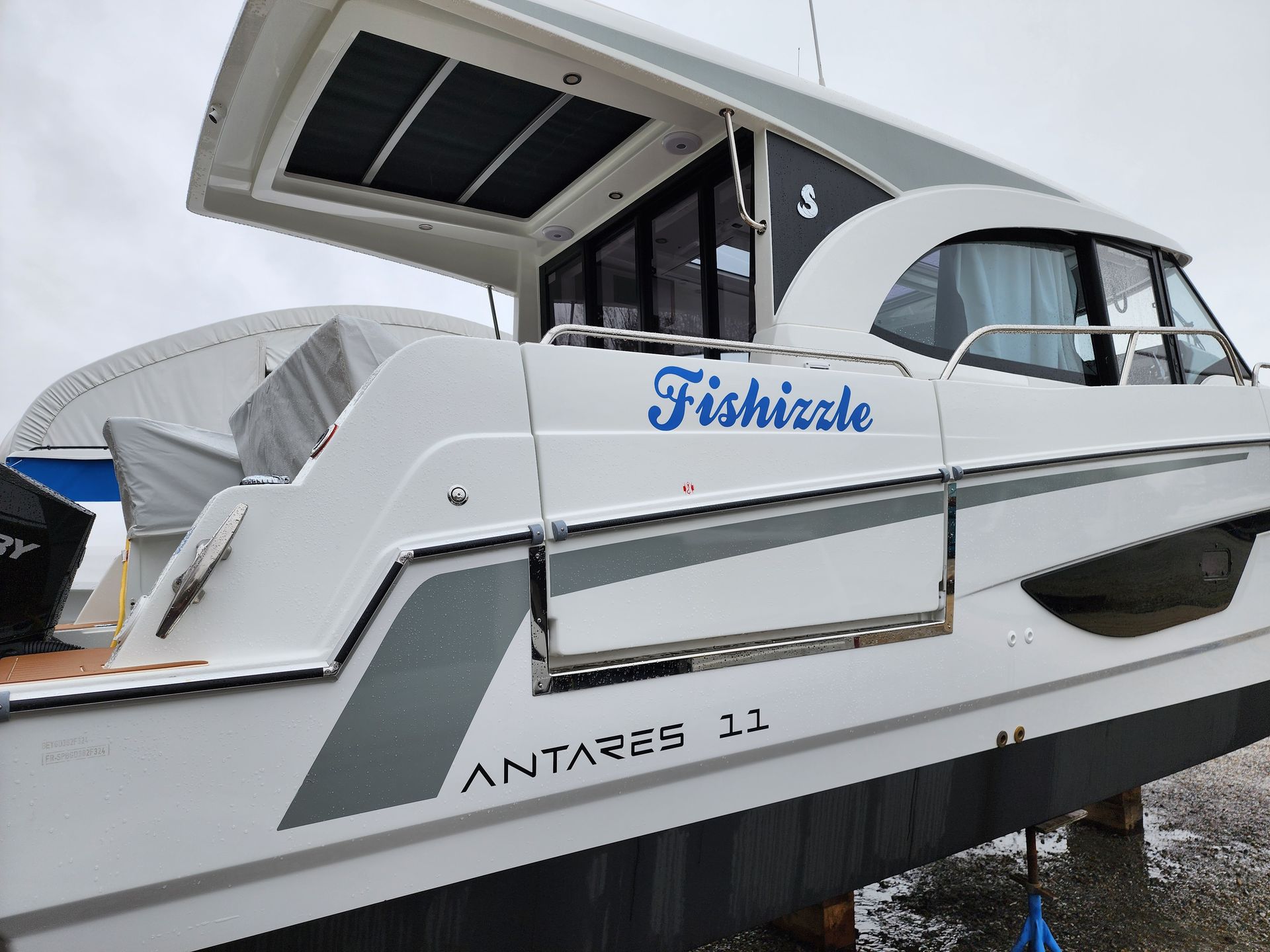 A white boat with the name fishizzle on it