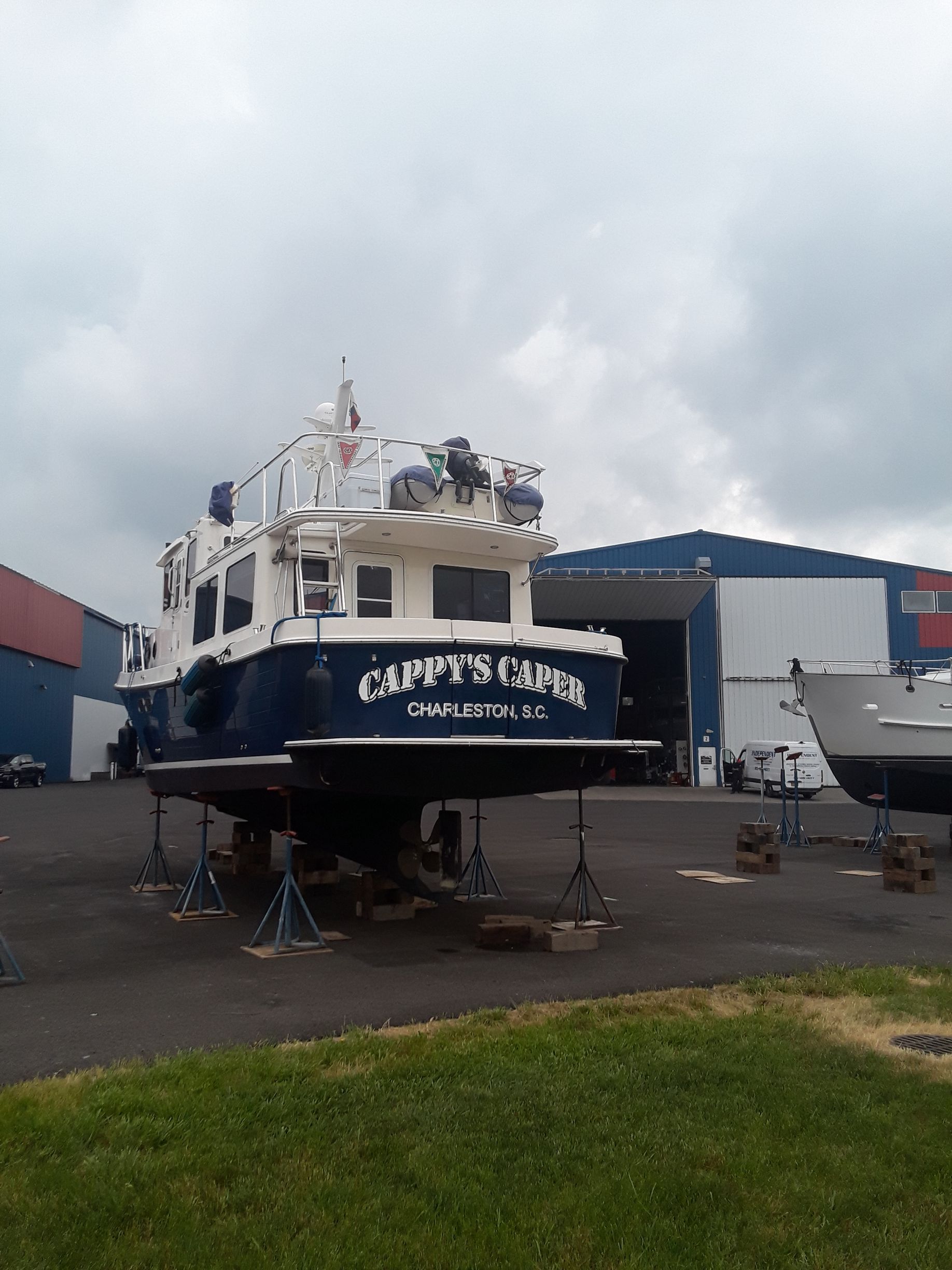 A boat is sitting in a parking lot in front of a building.
