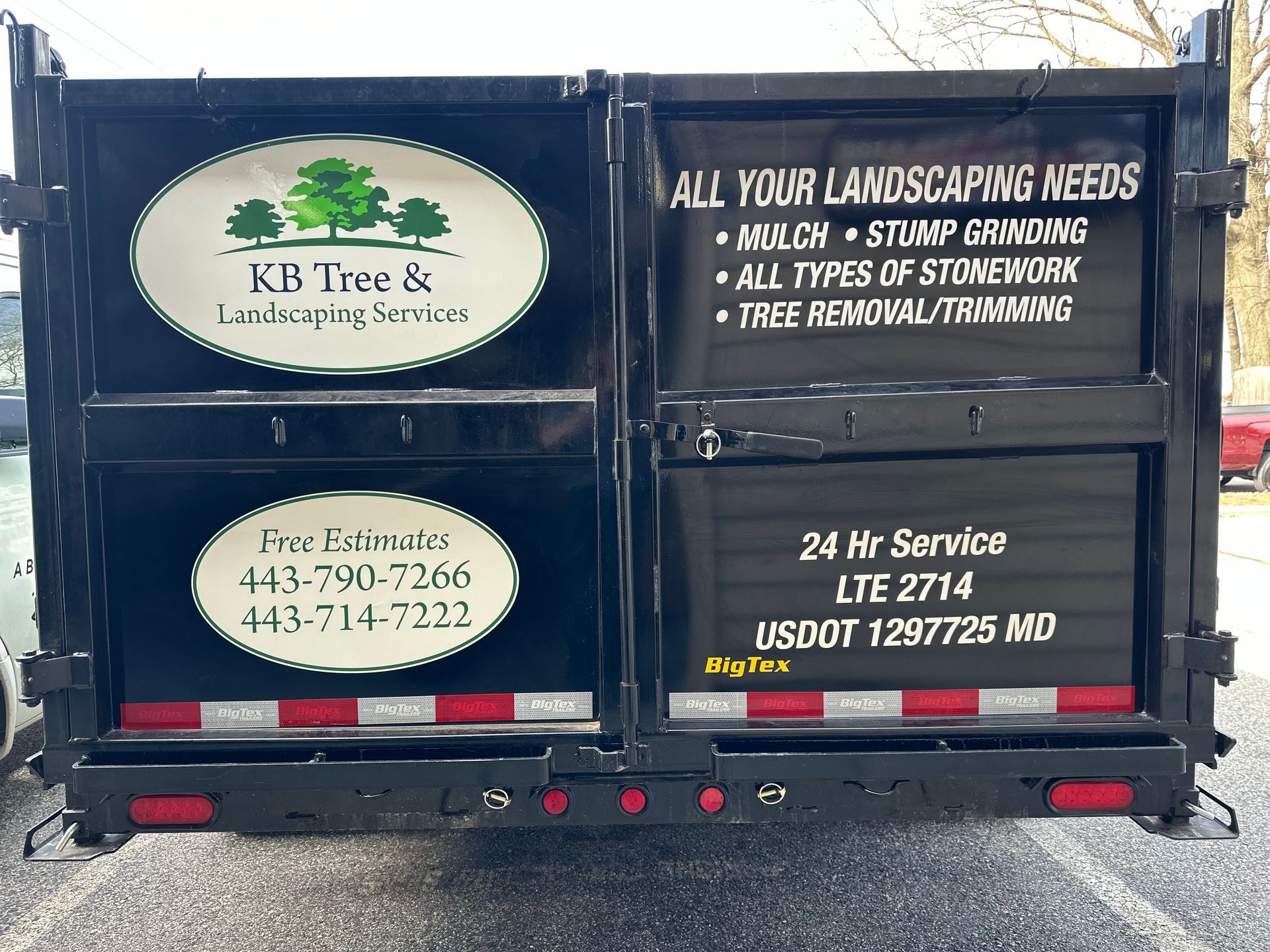 The back of a dumpster with a sign that says all your landscaping needs