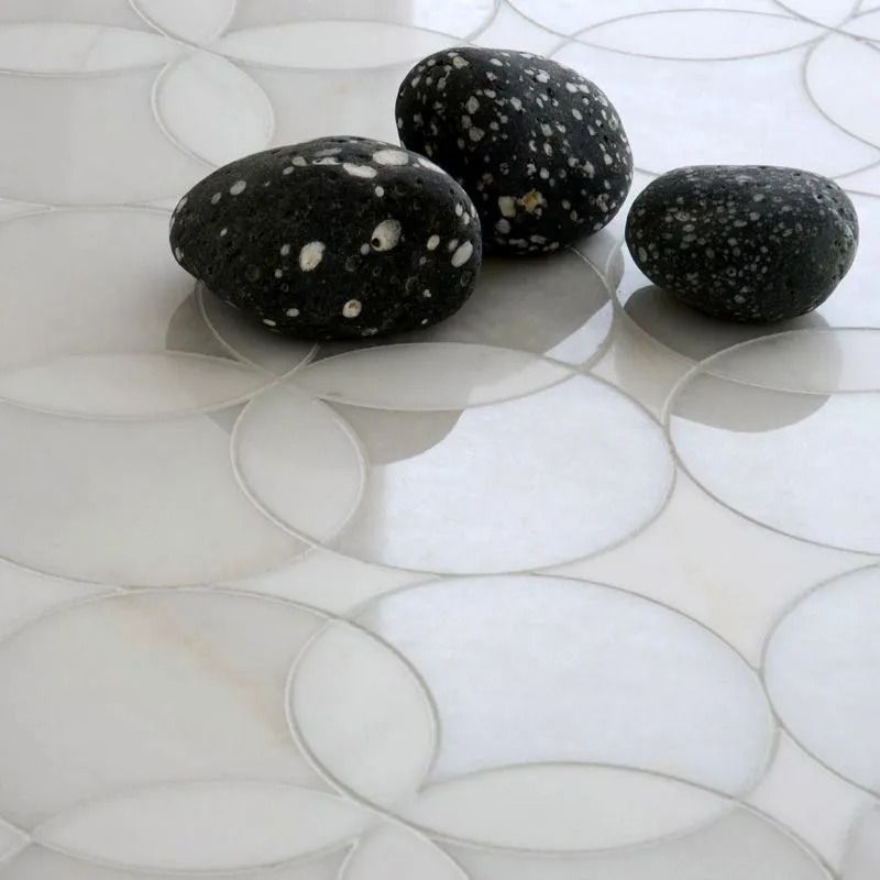 White oval tiles with three dark speckled stones.