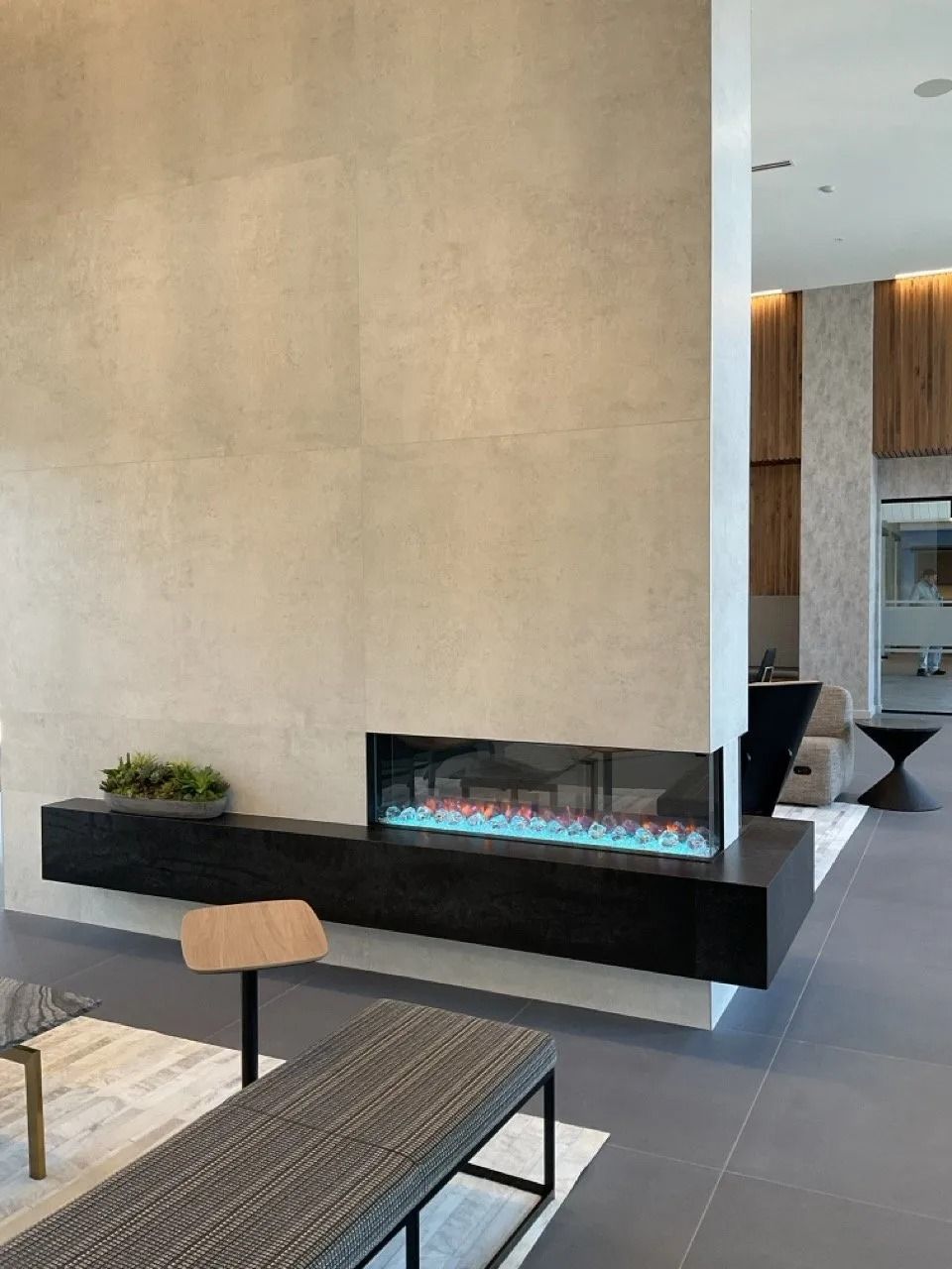 Modern living room with a linear fireplace set into a large stone wall.