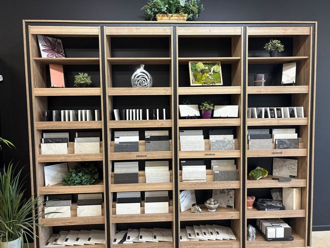 Display case with samples of tile, stone, and decorative items. Shelves are dark wood.