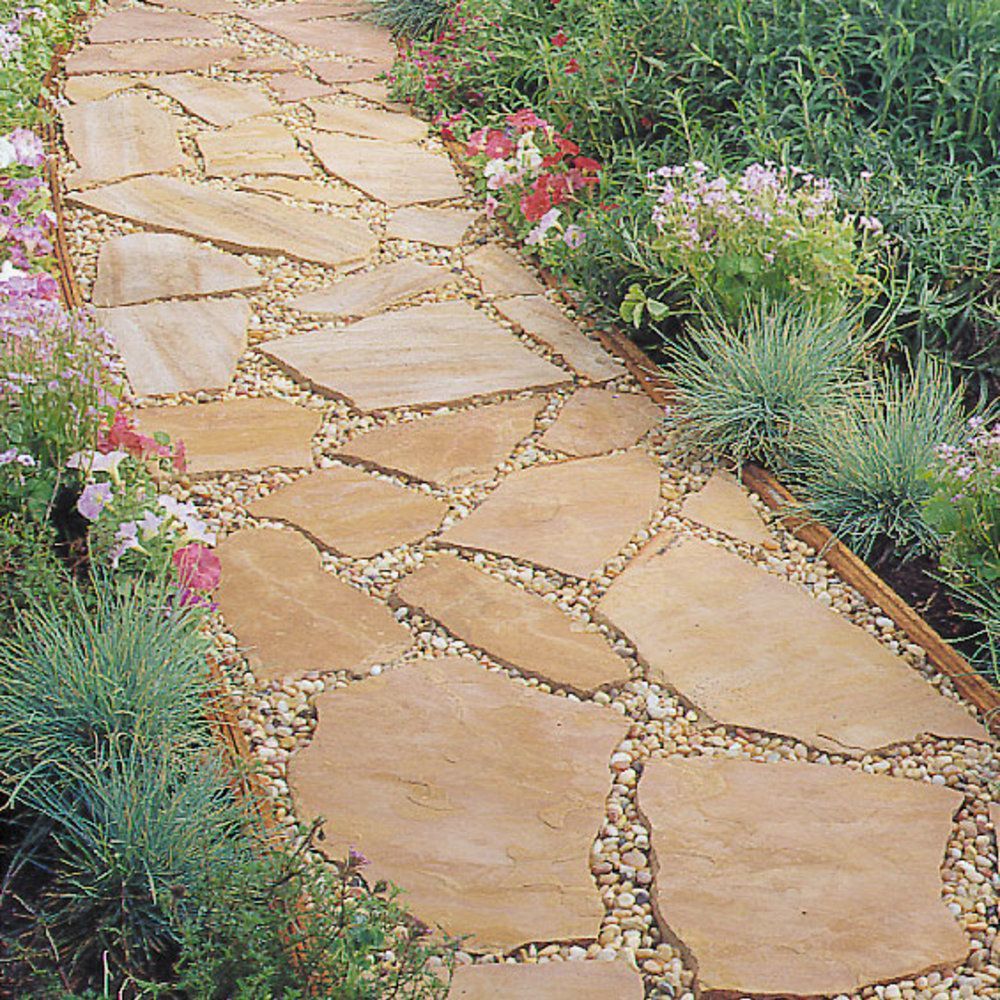 Stone pathway winding through a garden, bordered by flowers and small gravel.