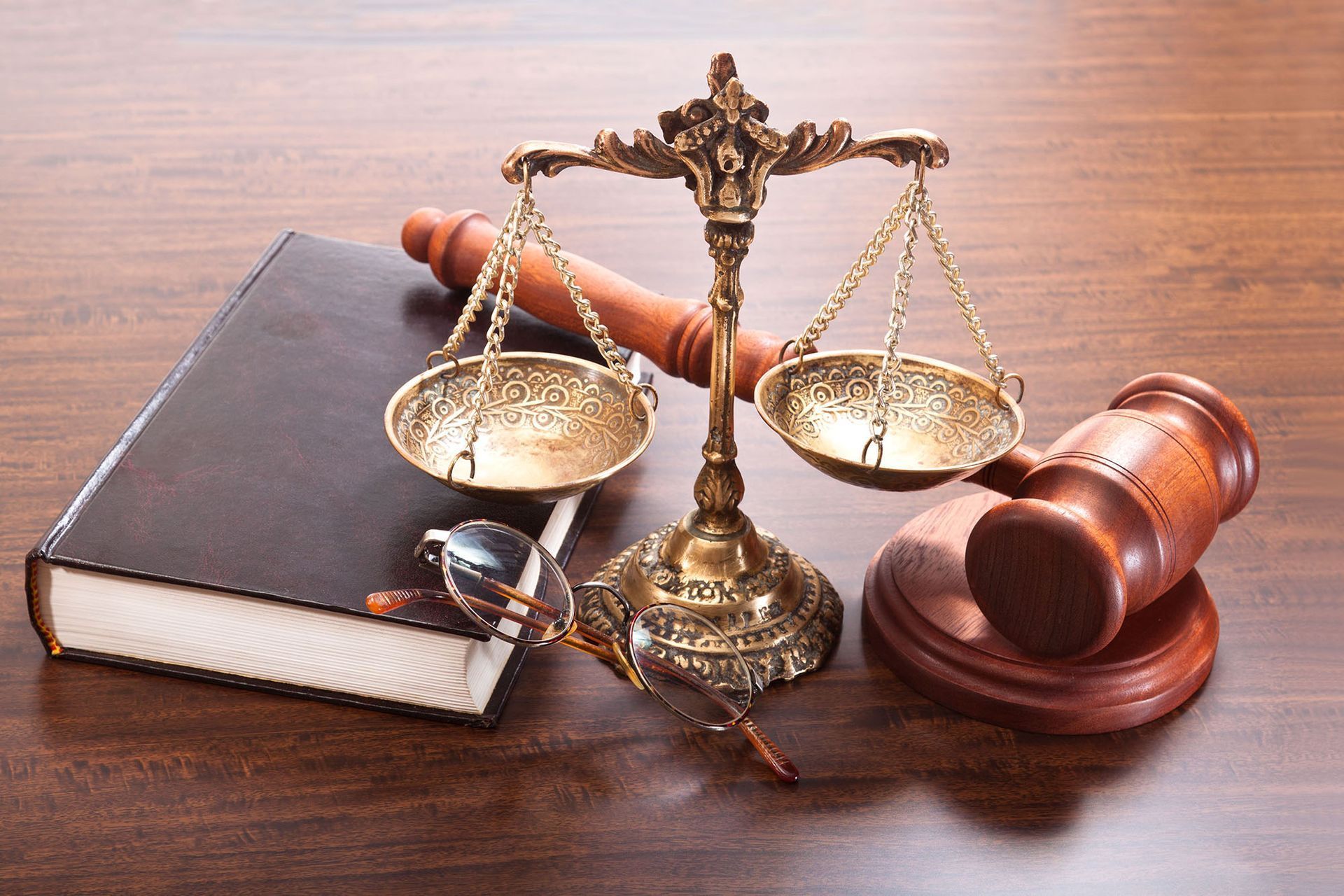 Handshake over legal documents with a gavel and scales of justice on a desk