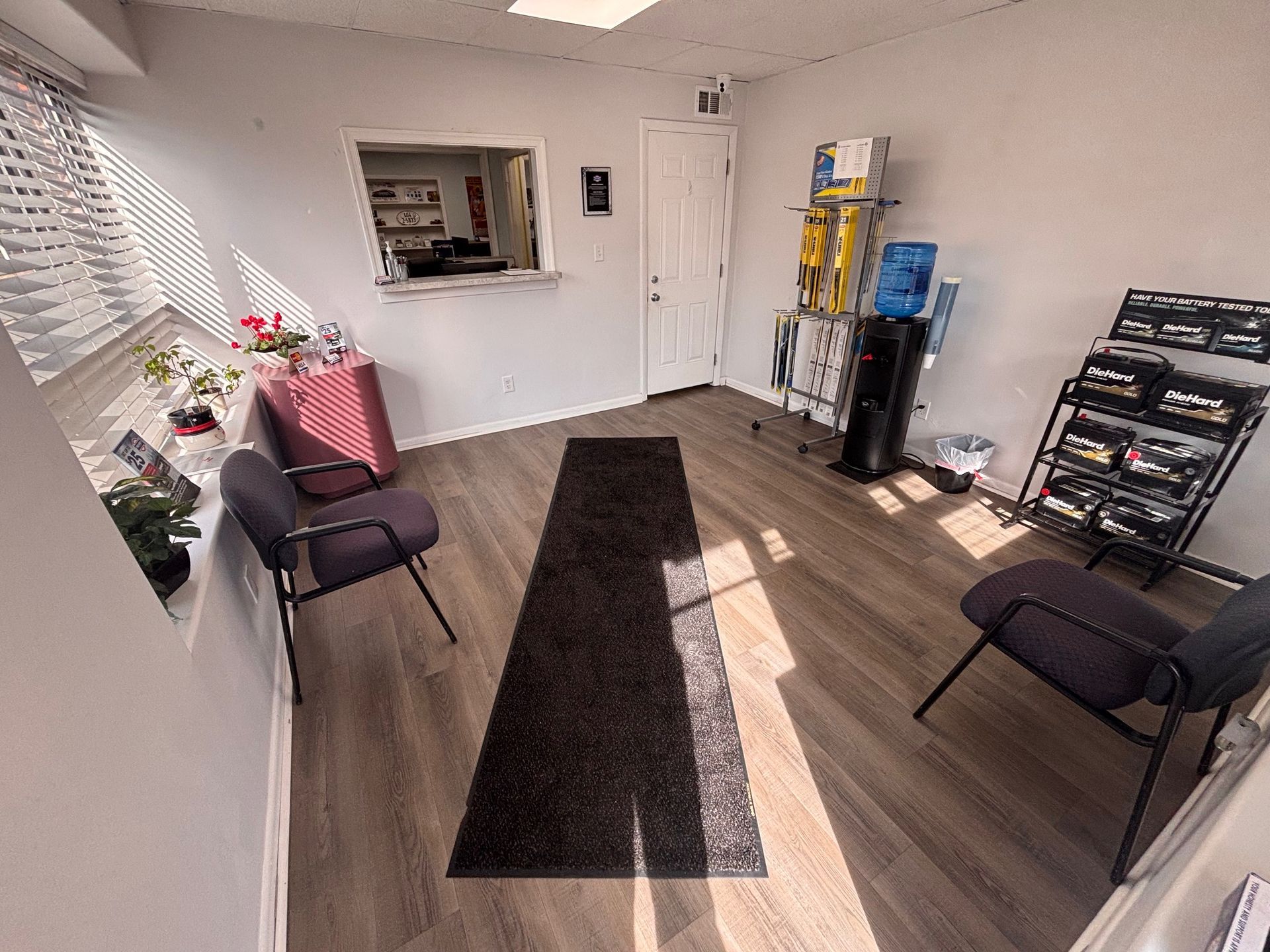 A well-lit waiting room with chairs, a water cooler, and a counter.