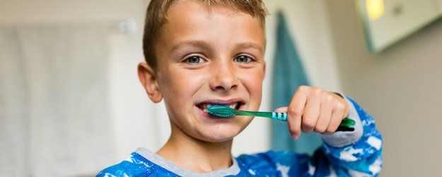 young boy brushing his teeth