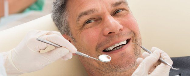 happy mature man having dental check-up in clinic