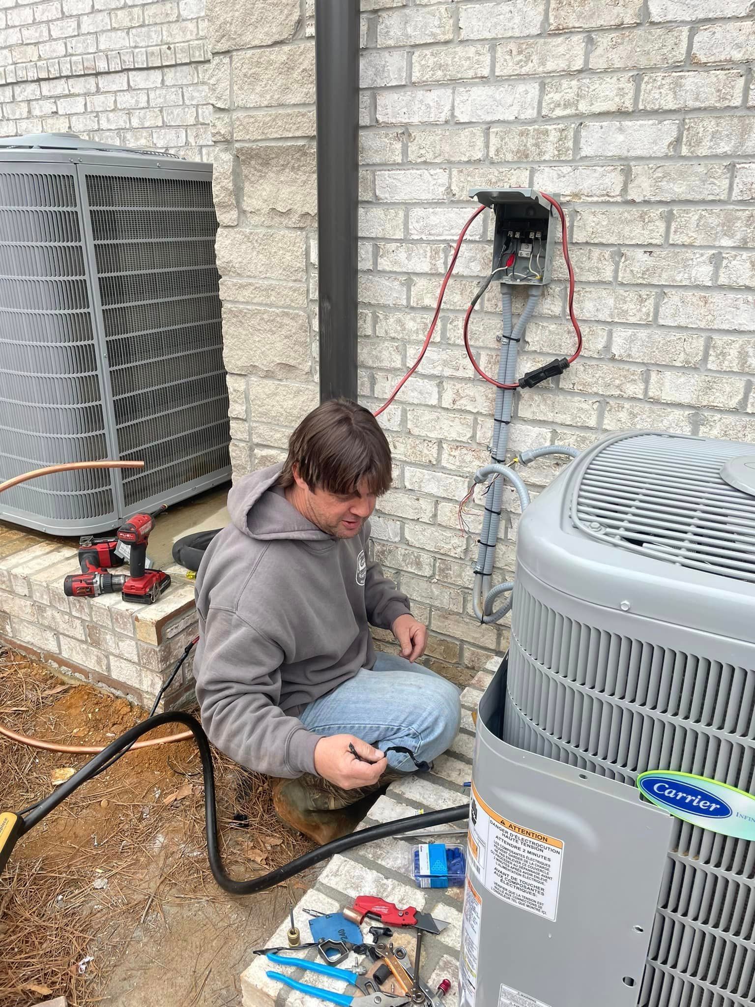 a man is working on an air conditioner outside of a brick building