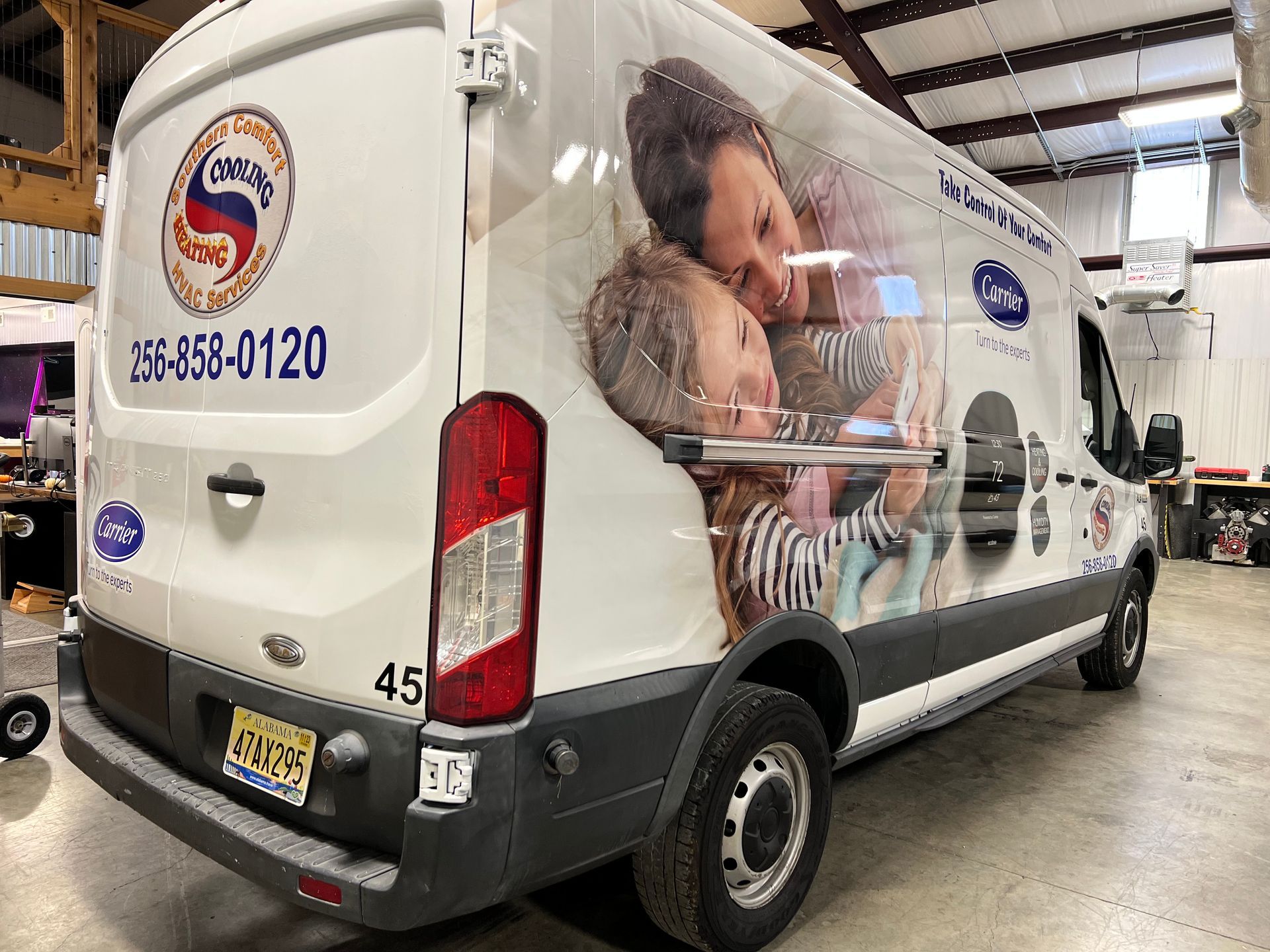 a white van with a picture of a mother and child on the back is parked in a garage