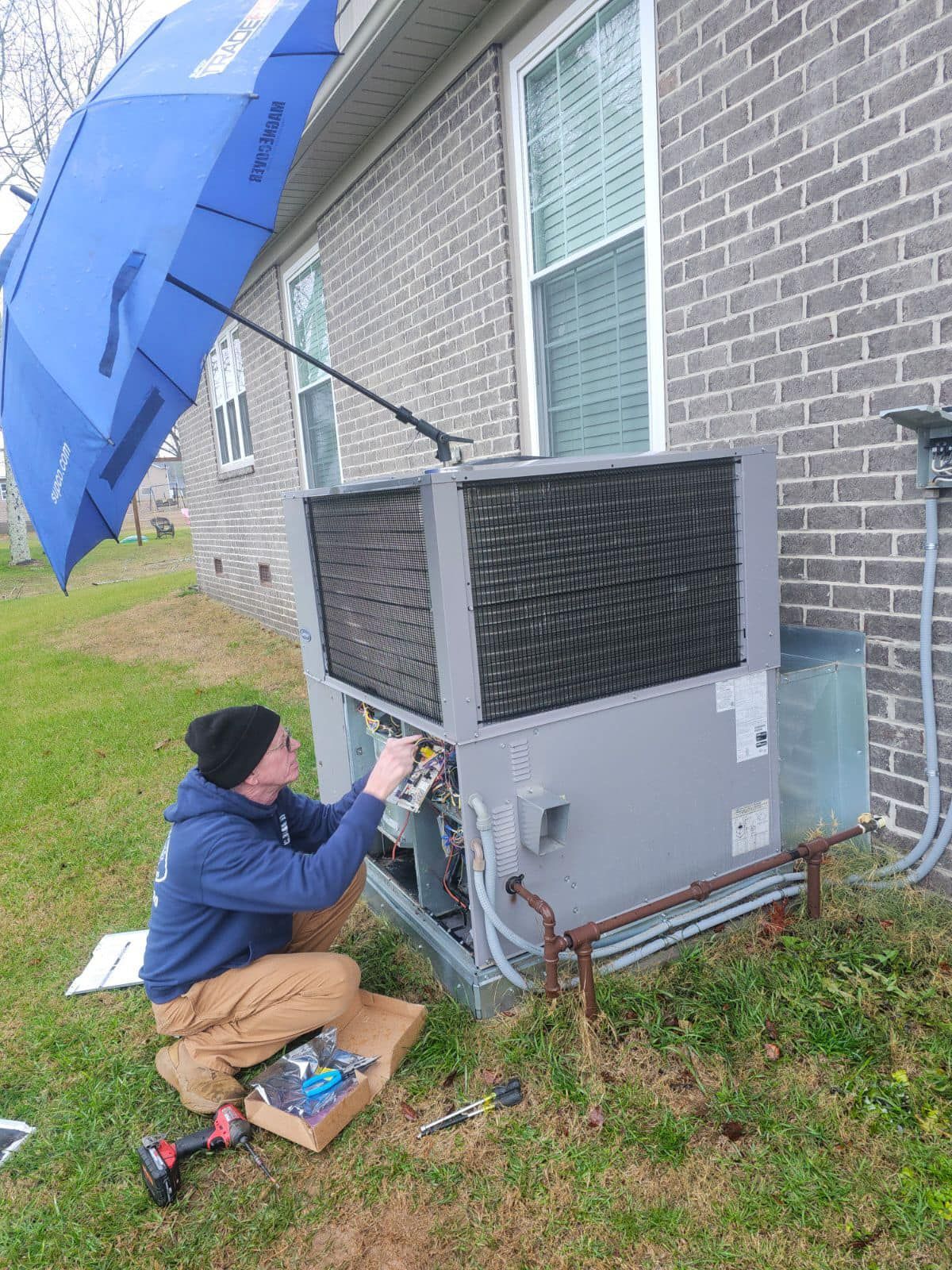a man is working on an air conditioner outside of a brick building